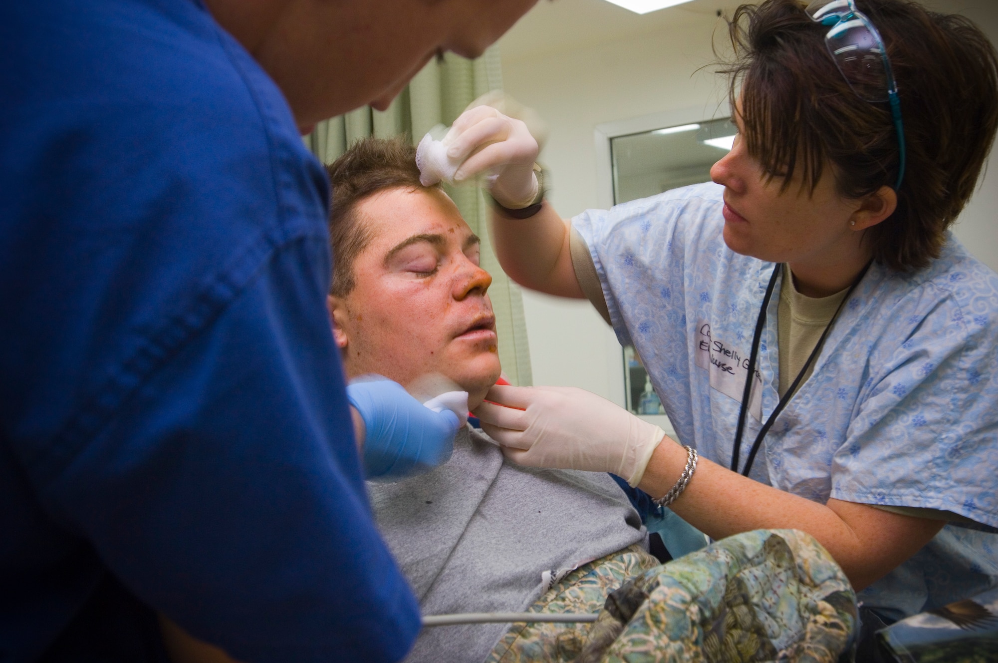 BALAD AIR BASE, Iraq -- Capt. Shelly Garceau, an emergency room nurse, cleans burns on the forehead of Spc. Christopher Burrell, 108th Military Police Company, at the Air Force Theater Hospital here. Specialist Burrell sustained the burns and lost his leg due to  an explosive formed penetrator during an attack near Sadr City. Capt. Garceau is deployed from Wilford Hall Medical Center, San Antonio, Texas. (U.S. Air Force photo/Tech. Sgt. D. Clare)