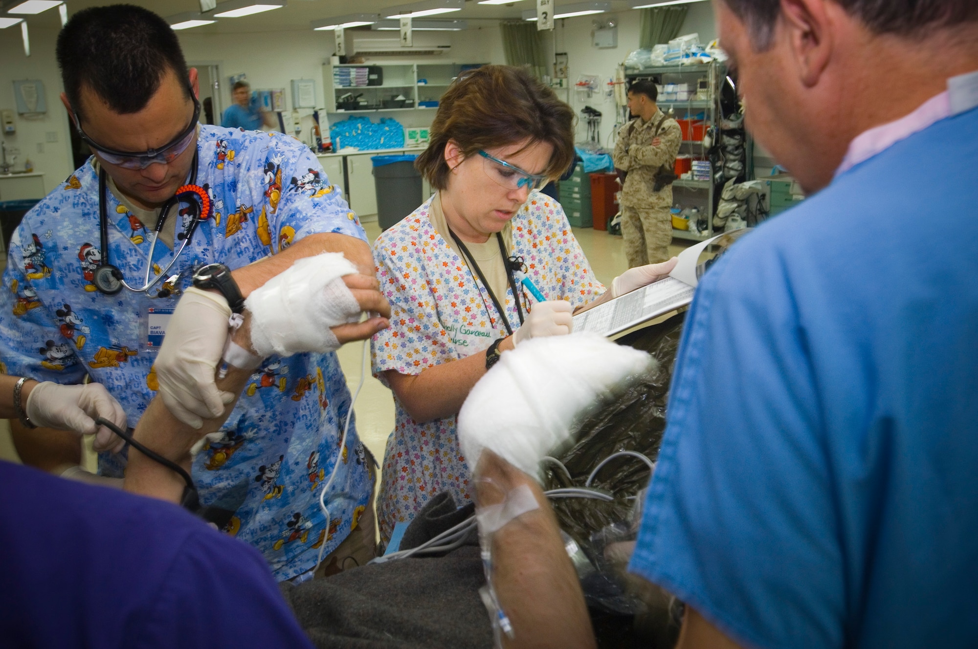 BALAD AIR BASE, Iraq -- Capt. Shelly Garceau, an emergency room nurse, records the vital signs of a Marine who suffered burns over his face and arms at the Air Force Theater Hospital here. Before deploying to Iraq, Captain Garceau was at Landstuhl Regional Medical Center in Germany receiving combat-wounded patientsfrom the AFTH. She is deployed from Wilford Hall Medical Center, San Antonio, Texas. (U.S. Air Force photo/Tech. Sgt. D. Clare)