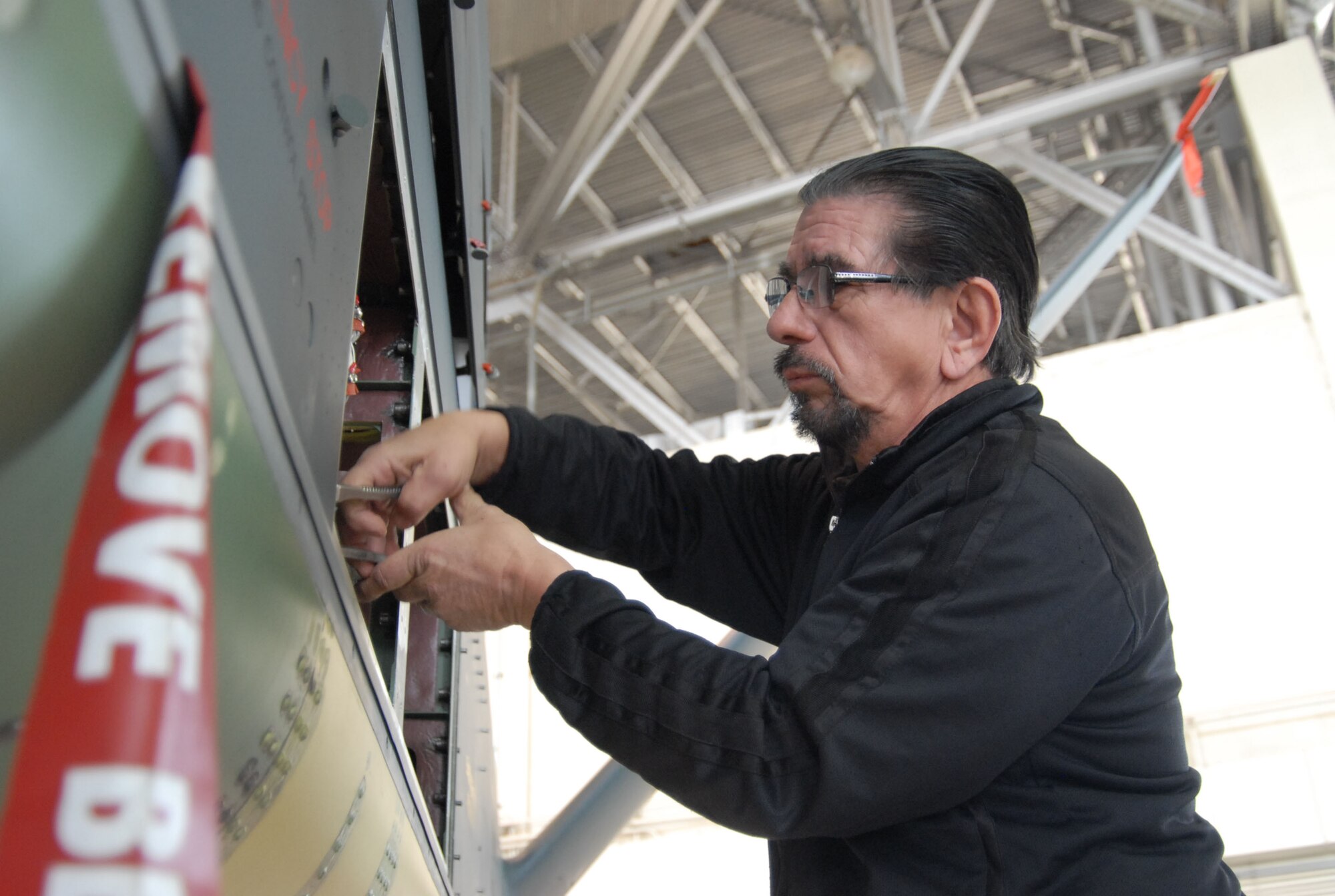 Francisco Rodriguez, Northrop Grumman flight test technician, tightens a connection in the power distribution controller of the RQ-4 Global Hawk Block 30. The aircraft arrived at Edwards on a ferry flight Nov. 16 from the Northrop Grumman Palmdale, Calif., facility. (Photo by Senior Airman Julius Delos Reyes)