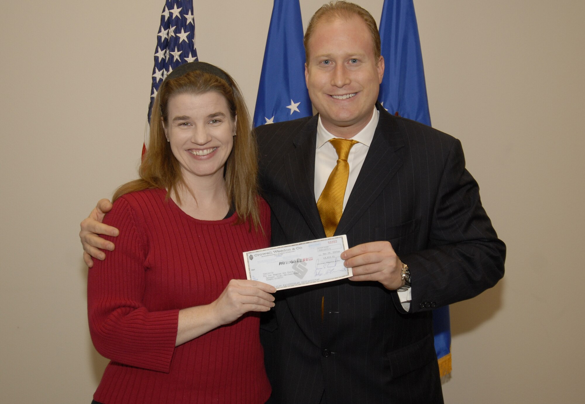 Joseph Goldstein presented more than $6,000 to Los Angeles AFB Spouses Club, Dec. 28.  The donation was made to the base by The Goldstein Family Foundation and will be used for scholarships, care packages for deployed members and the Airman’s Attic.  Pictured from left to right is Amy Cummins, LAAFB Spouses Club, and Joseph Goldstein. (Photo by Joe Juarez)