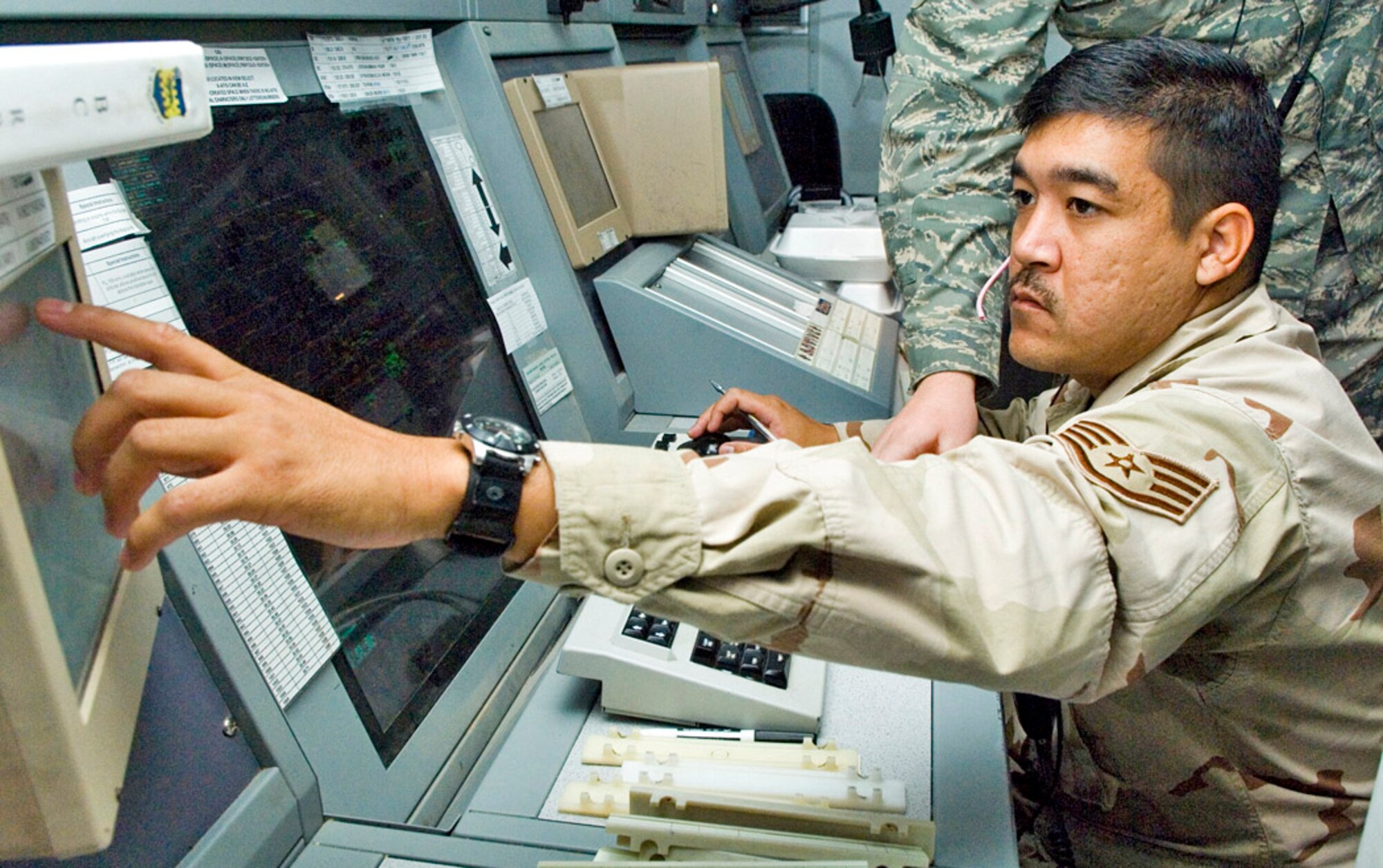 Staff Sgt. Gilbert Lanai uses the enhanced terminal voice switch inside the combined en route radar approach control facility at Balad Air Base, Iraq, to coordinate with adjacent sectors in Iraq. The ETVS is a new addition that allows controllers to touch the screen to talk to someone on a "shout" line or call line. Sergeant Lanai is a 332nd Expeditionary Operations Support Squadron air traffic controller deployed from the Hawaii Air National Guard. (U.S. Air Force photo/Senior Airman Travis Edwards) 