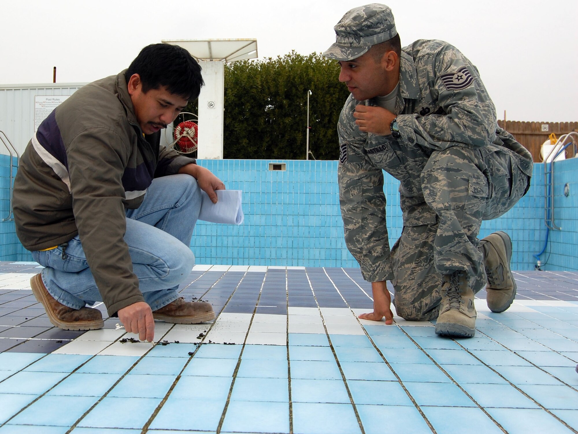 SOUTHWEST ASIA -- Tech. Sgt. Edwin Del Castillo discusses the best way to complete repairs on the base pool with a host country contractor Jan. 3 at an air base in the Middle East. The pool is scheduled to reopen Jan. 10. Sergeant Del Castillo is the 386th Expeditionary Services Squadron fitness center manager and is from Barksdale Air Force Base, La. (Air Force photo\Staff Sgt. Phillip Butterfield) 


