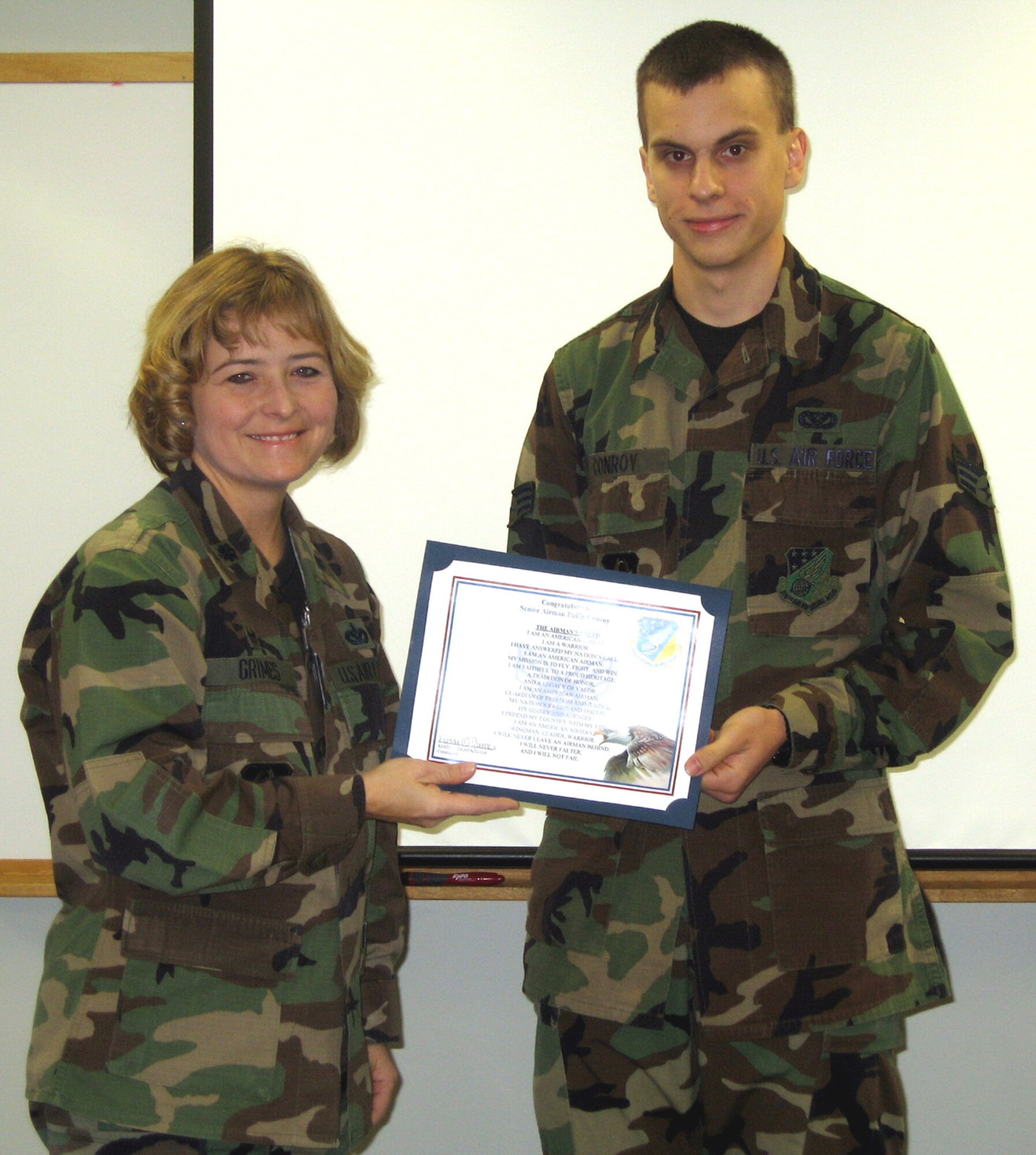 SEYMOUR JOHNSON AIR FORCE BASE, N.C.--Senior Airman Philip Conroy, a utilities technician with the 916th Civil Engineer Squadron here, received his promotion certificate during the 916th Air Refueling Wing's Unit Training Assembly in December. Next to him is his commander, Lt. Col. Kerri Grimes.