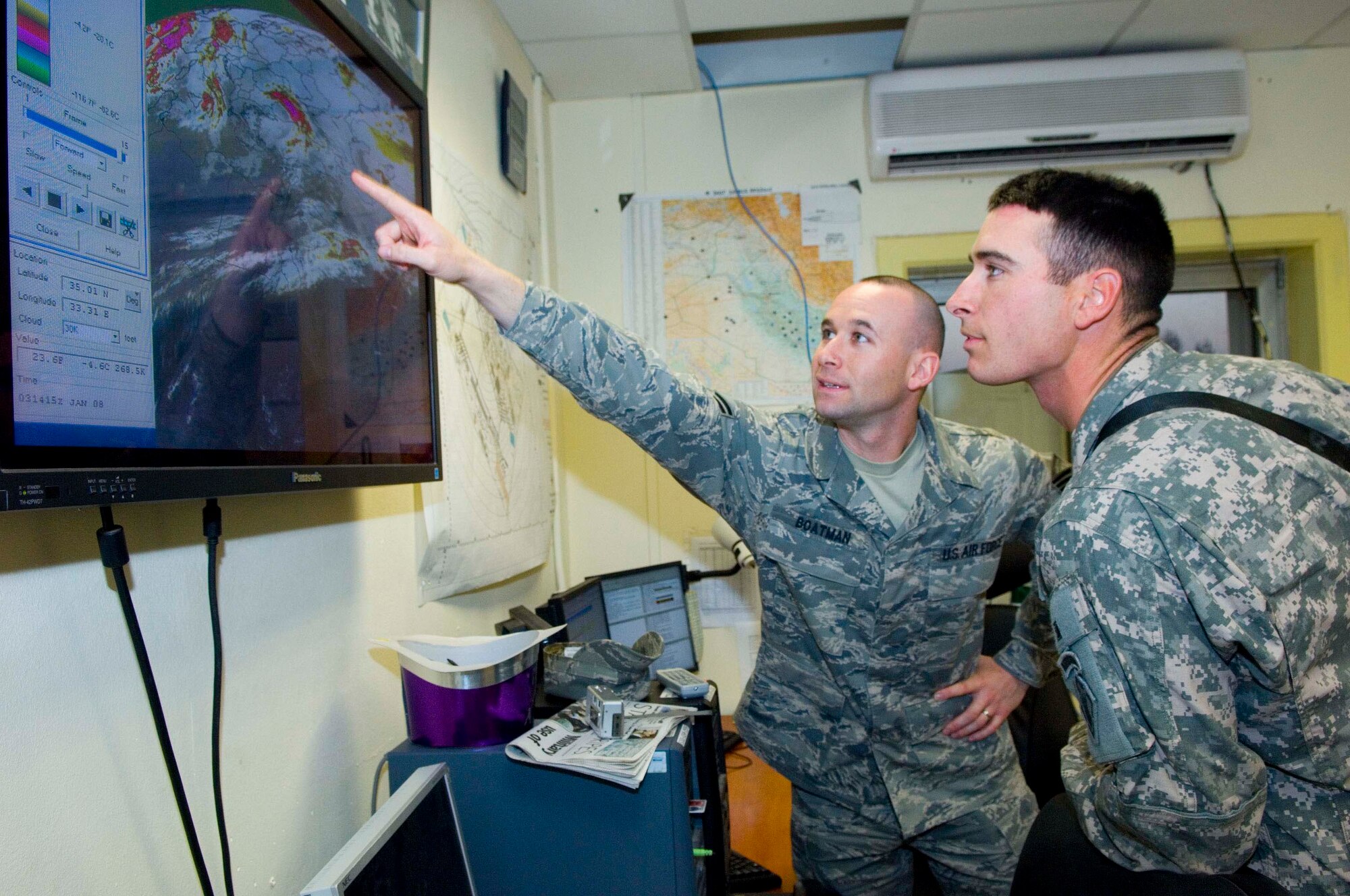 BALAD AIR BASE, Iraq -- Staff Sgt. Brad Boatman, left, a 332nd Expeditionary Operations Support Squadron weather forecaster, points out an area on the weather satellite where there may be possible thunderstorms to his brother, Army Sgt. Matt Boatman. It has been three years since the two have seen each other. Sergeant Brad Boatman is deployed from Fairchild Air Force Base, Wash., and his younger brother is deployed from Fort Campbell, Ky. The brothers are both from Amarillo, Texas. (U.S. Air Force photo/Staff Sgt. Travis Edwards)