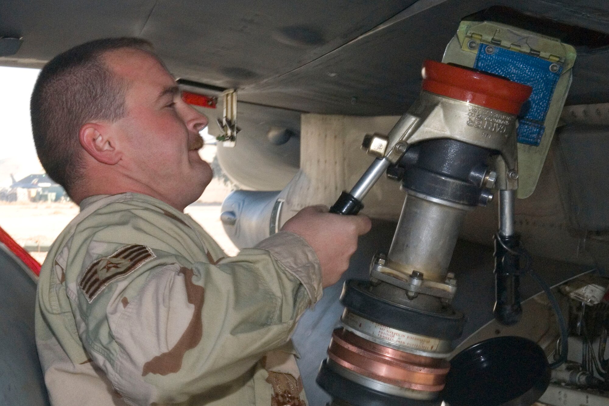 BALAD AIR BASE, Iraq -- Staff Sgt. James Bersaglia, a 332nd Aircraft Maintenance Unit crew chief, releases a fuel line from an F-16 Fighting Falcon here, Jan. 4. All aircraft are refueled and inspected for any discrepancies when they return from a mission. Sergeant Bersaglia is deployed from Spangdahlem Air Base, Germany.  (U.S. Air Force photo/Staff Sgt. Joshua Garcia) 