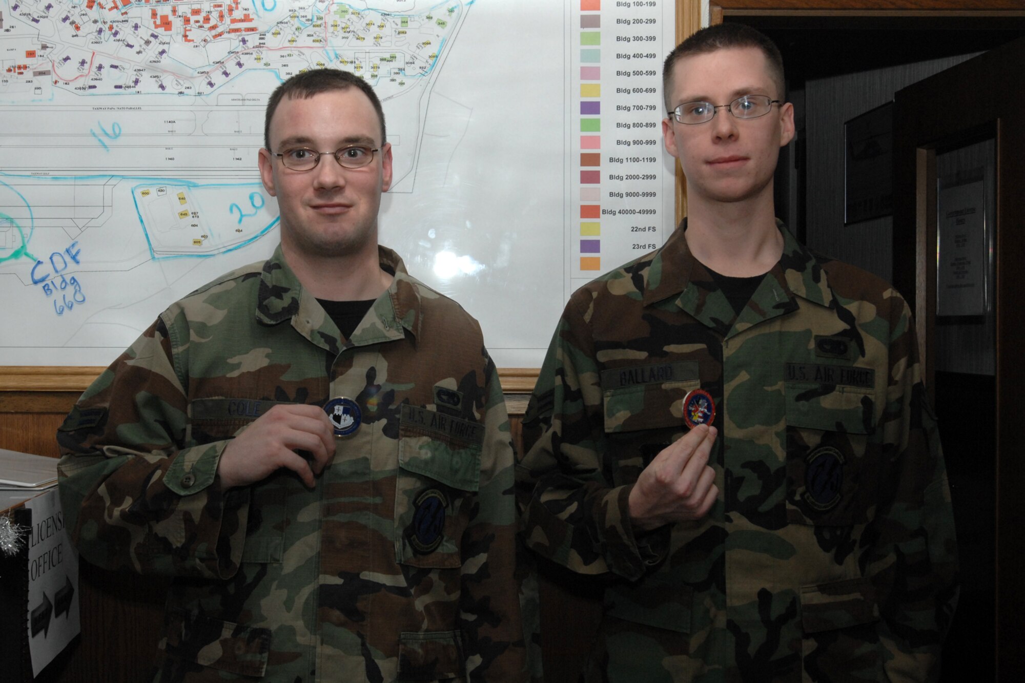 SPANGDAHLEM AIR BASE, Germany -- Airman 1st Class Adam Cole and Airman First Class Johnathan Ballard display the 52nd Fighter Wing Coins they received from Col. Darryl Roberson, 52nd FW commander, at vehicle dispatch Dec. 21, 2007. The Airmen received a coin for their superior craftsmanship in maintaining the commander’s government vehicle. (U.S. Air Force photo/Airman 1st Class Jenifer Calhoun)