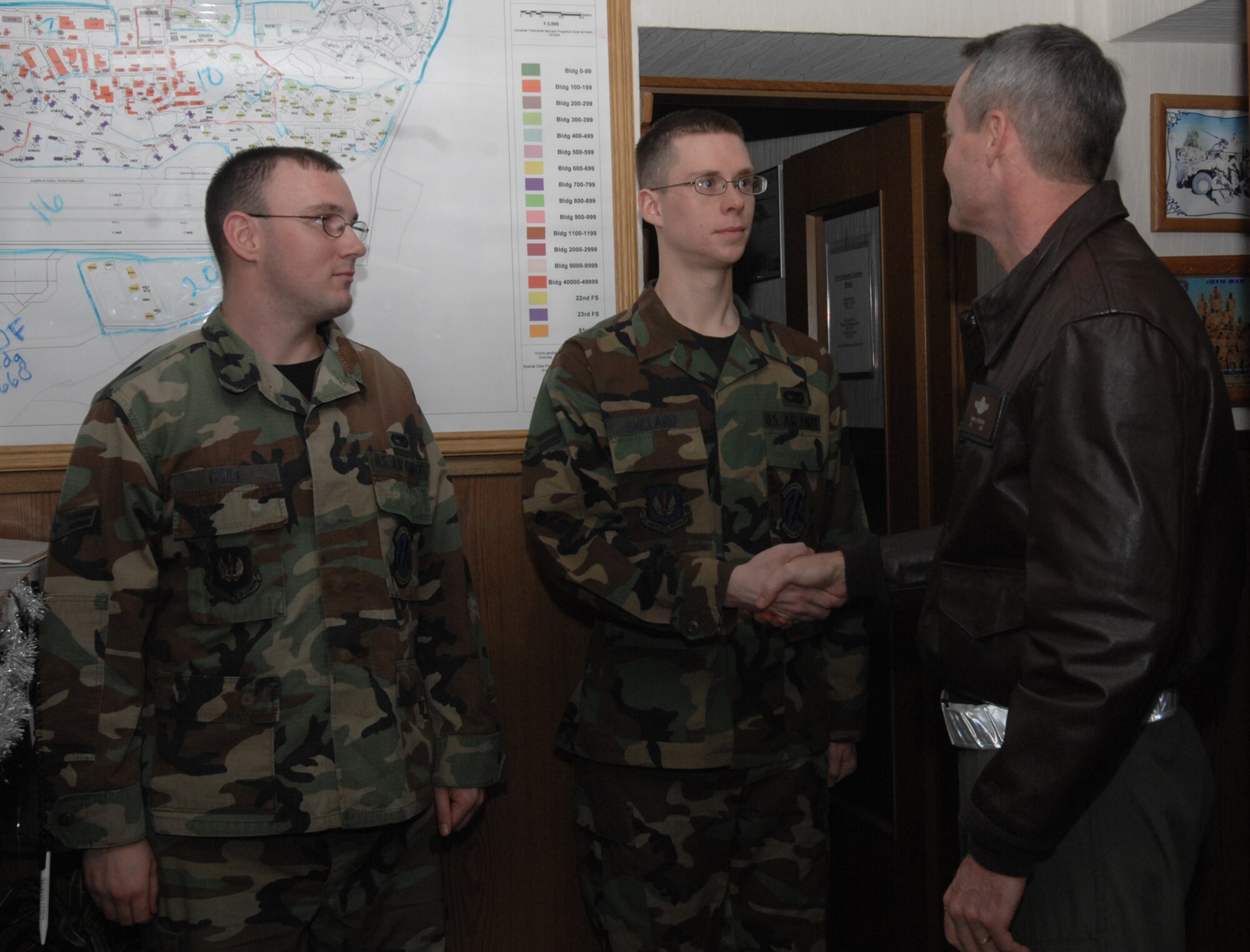 SPANGDAHLEM AIR BASE, Germany -- Airman 1st Class Johnathan Ballard, 52nd Logistics Readiness Squadron, receives a 52nd Fighter Wing coin from Col. Darryl Roberson, 52nd FW commander, at vehicle dispatch Dec. 21, 2007. Airman Ballard was coined for his superior craftsmanship in maintaining the commander’s government vehicle. (U.S. Air Force photo/Airman 1st Class Jenifer Calhoun)