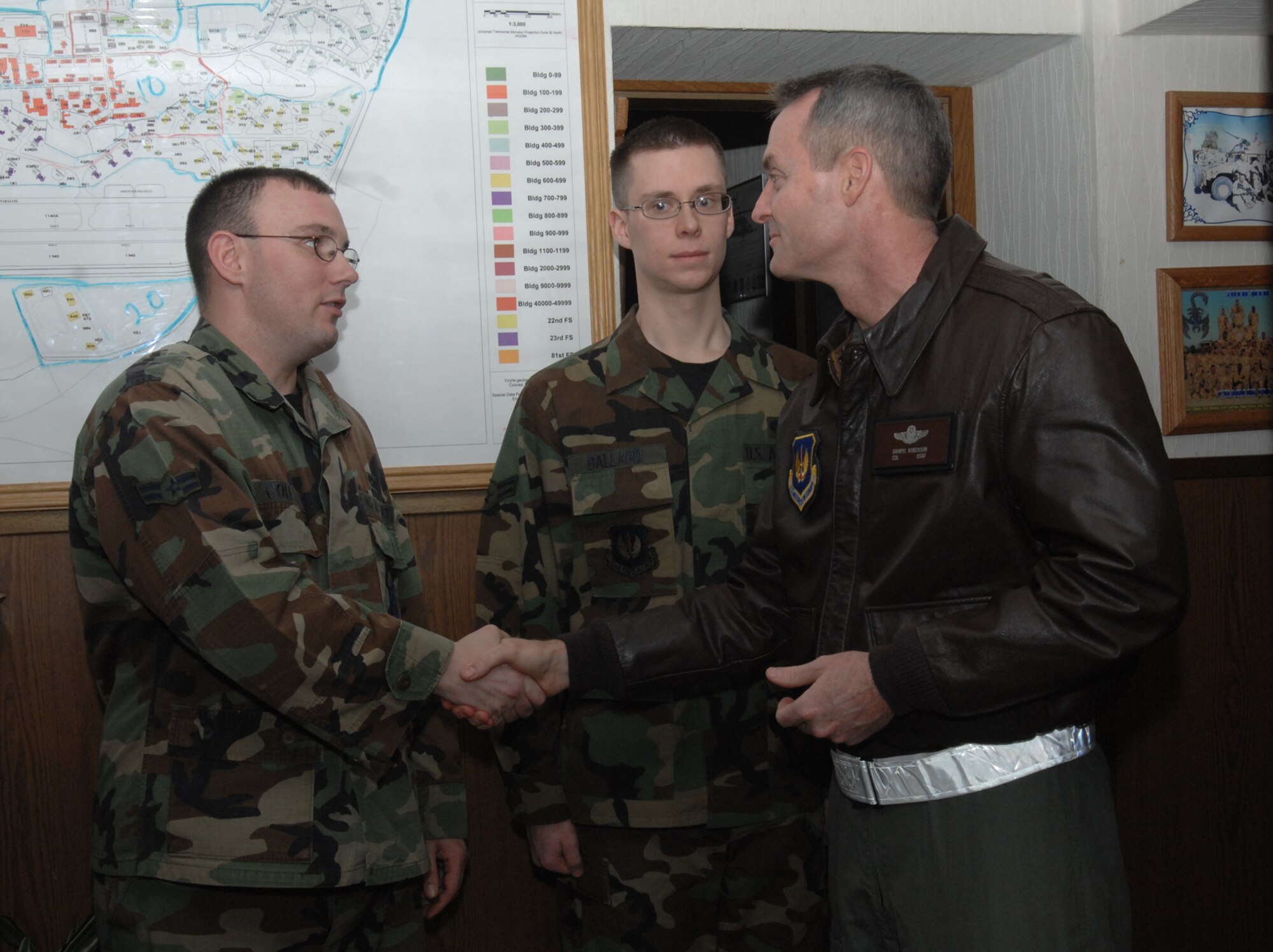 SPANGDAHLEM AIR BASE, Germany -- Airman 1st Class Adam Cole, 52nd Logistics Readiness Squadron, receives a 52nd Fighter Wing coin from Col. Darryl Roberson, 52nd FW commander, at vehicle dispatch Dec. 21, 2007. Airman Cole was coined for his superior craftsmanship in maintaining the commander’s government vehicle. (U.S. Air Force photo/Airman 1st Class Jenifer Calhoun)