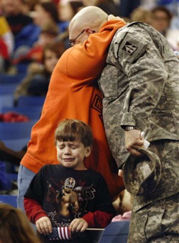 U.S. Army Sgt. Shane Pudgett, of the 76th Infantry Brigade Combat Team, hugs his wife goodbye as his son cries during a going away ceremony at the RCA Dome in Indianapolis, Ind., on Jan. 2, 2008.  The Indiana National Guard is preparing to deploy its largest amount of soldiers since World War II with more than 3,400 soldiers scheduled to depart for Iraq to serve during their 12-month rotation.  