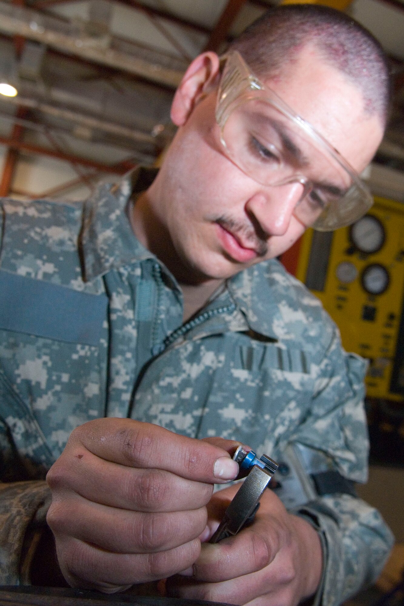 BALAD AIR BASE, Iraq -- Staff Sgt. Bobby Hausermann, a 332nd Expeditionary Maintenance Squadron aircraft ground equipment maintainer, removes a removes a cap seal from a defective piece of hydraulic line. The cap will securely fasten flared hydraulic lines to components on the hydraulic test stand. Sergeant Hausermann is deployed from Spangdahlem Air Base, Germany.  (Air Force photo/Staff Sgt. Joshua Garcia) 