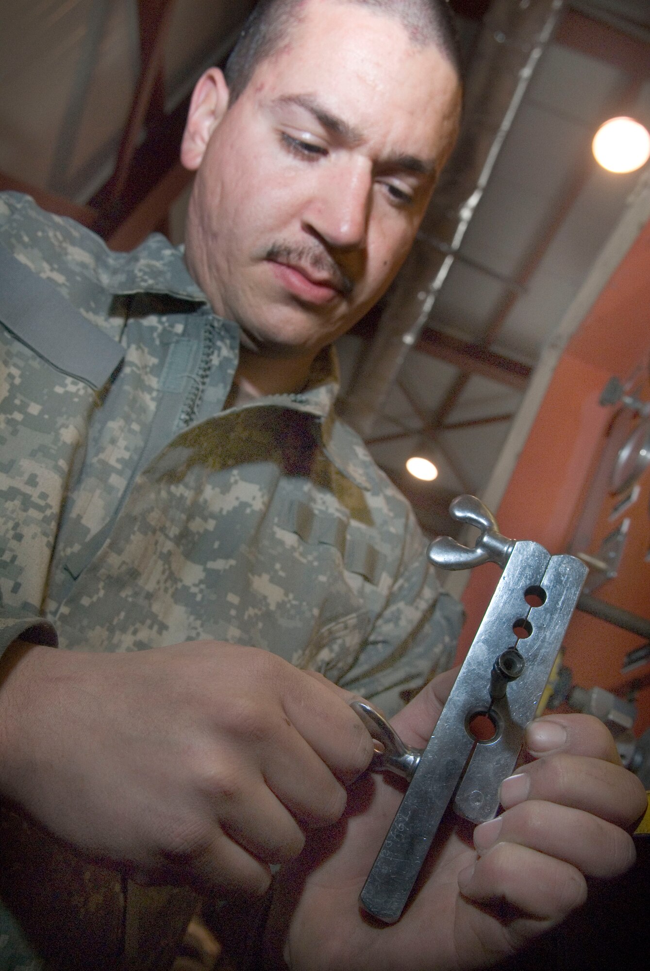 BALAD AIR BASE, Iraq -- Staff Sgt. Bobby Hausermann, a 332nd Expeditionary Maintenance Squadron aircraft ground equipment maintainer deployed from Spangdahlem Air Base, Germany, tightens a flare tool to a hydraulic line here Jan. 5. The flare tool will allow Sergeant Hausermann to flare the tip of the line to fit components on the equipment. (Air Force photo/Staff Sgt. Joshua Garcia) 