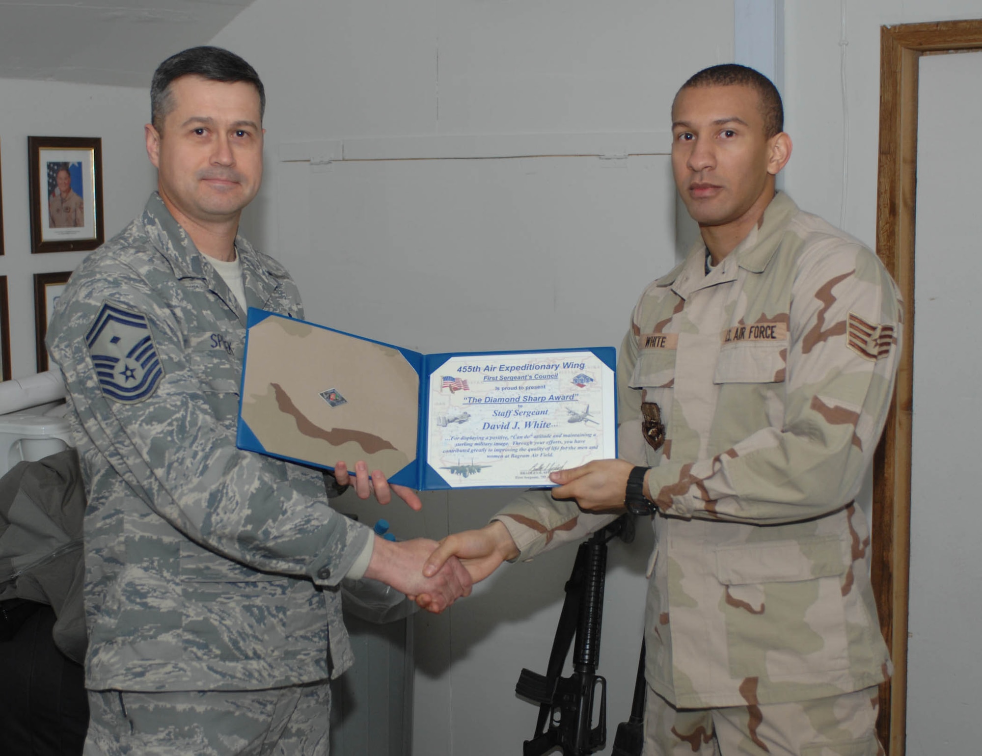 Senior Master Sgt. Bradley Spilinek, 755th Air Expeditionary Group First Sergeant presents a “Diamond Sharp” award to Staff Sgt. David J. White, 455th Air Expeditionary Wing Command Post, here Jan. 3.  The Diamond Sharp awards are sponsored by the wing’s first sergeants and recognize individuals that display a positive, “can do” attitude and maintain “a sterling military image at all times.” Sergeant Smith was recognized for his support to Operation Care, a volunteer effort which among several things, provides snacks, hygiene, and morale items to servicemembers at isolated forward operating bases. (U.S. Air Force Photo by Staff Sgt. Mike Andriacco)