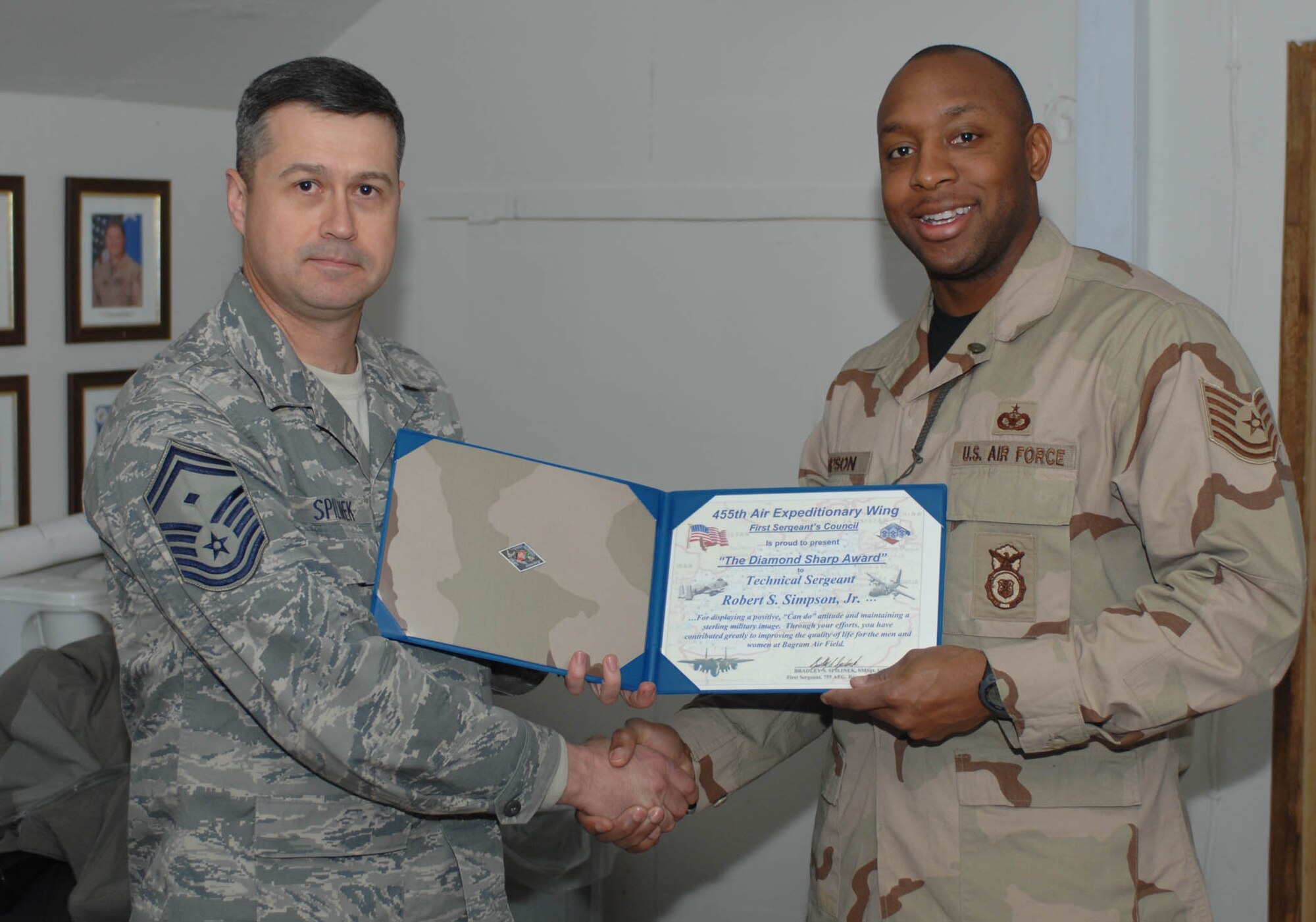 Senior Master Sgt. Bradley Spilinek, 755th Air Expeditionary Group First Sergeant presents a “Diamond Sharp” award to Tech. Sgt. Robert S. Simpson, Jr., 455th Expeditionary Security Forces Squadron, here Jan. 3.  The Diamond Sharp awards are sponsored by the wing’s first sergeants and recognize individuals that display a positive, “can do” attitude and maintain “a sterling military image at all times.” Sergeant Smith was recognized for his support to Operation Care, a volunteer effort which among several things, provides snacks, hygiene, and morale items to servicemembers at isolated forward operating bases. (U.S. Air Force Photo by Staff Sgt. Mike Andriacco)