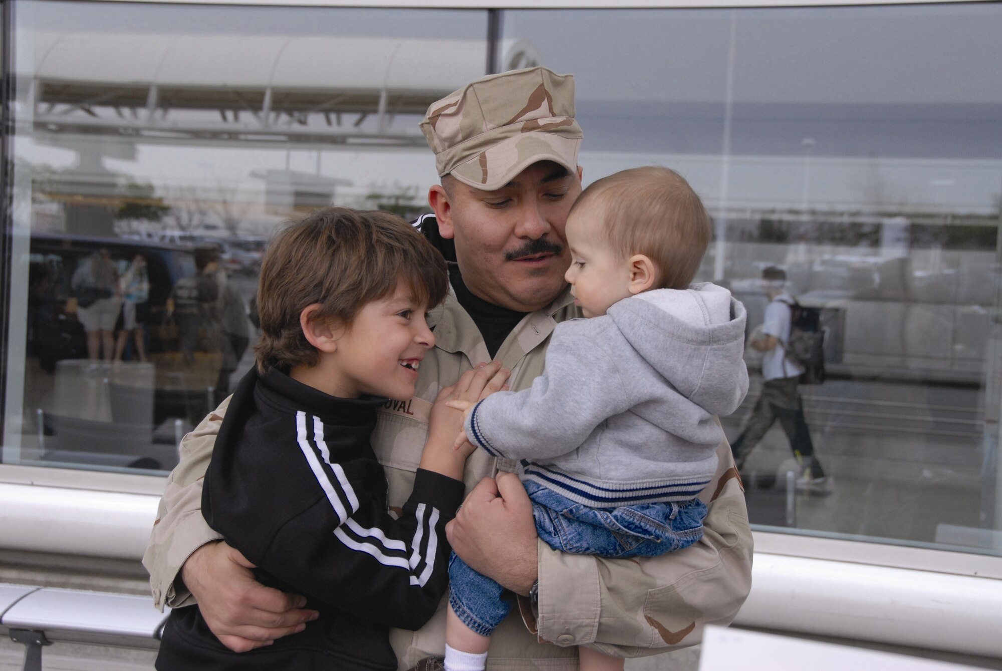 Senior Master Sgt. Tony Sandoval hugs his children when greeted by them at the airport in Ontario, California on February 9. The 163 RW Security Forces Personnel returned from the Middle East after a 120-day tour to March Air Reserve Base. (U.S. Air Force photo by Senior Airman Diane Ducat)
