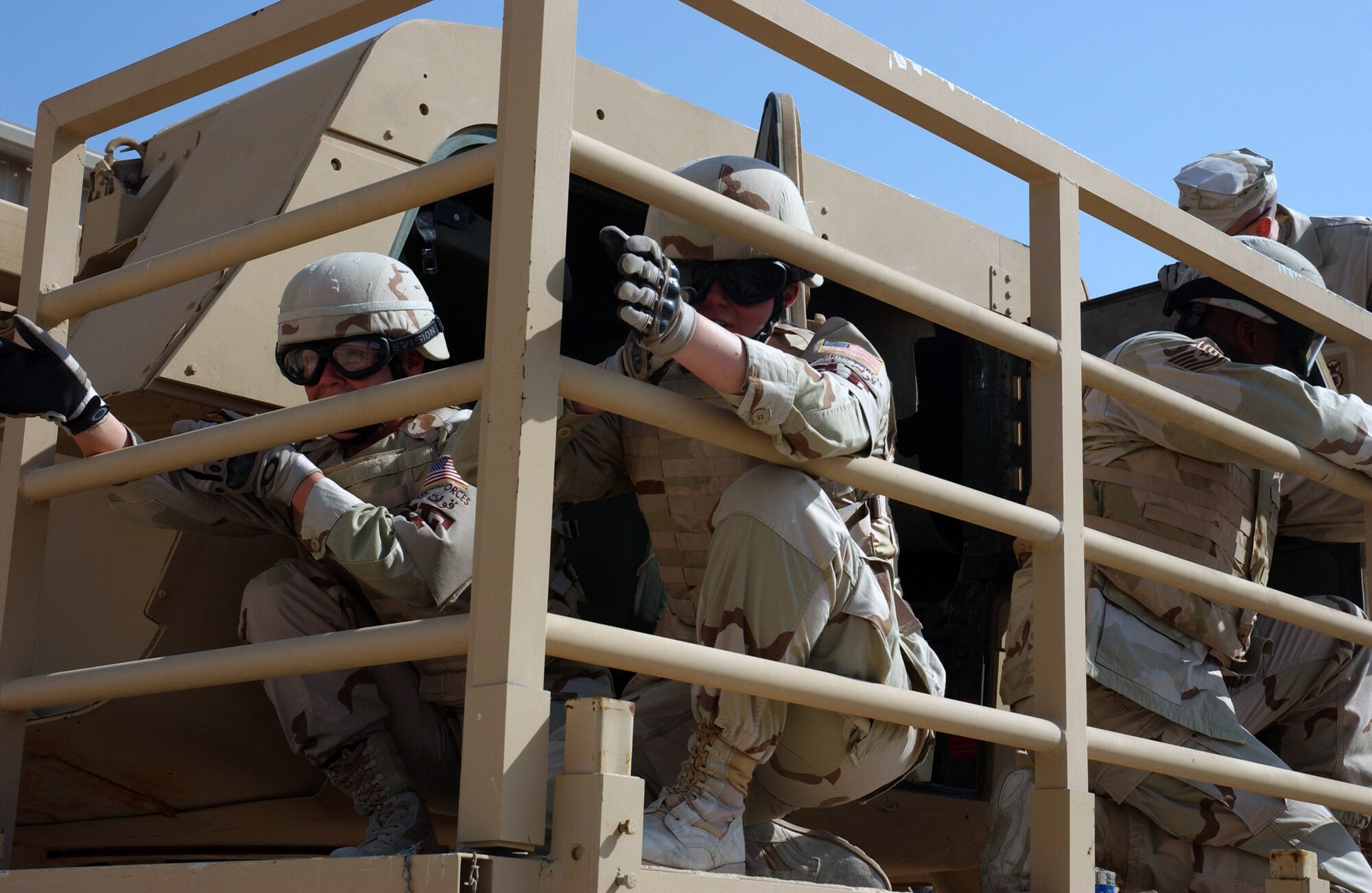 Airmen from the 379th Expeditionary Security Forces safely egress an inverted "Humvee" and take up positions to secure the perimeter against the enemy during specialized training at an Army camp in Southwest Asia.  The training, using a rollover Humvee simulator, teaches Airmen how to escape an inverted Humvee and increase their chance of survival after a catastrophic event.  (U.S. Air Force photo/Tech. Sgt. Sabrina Foster)