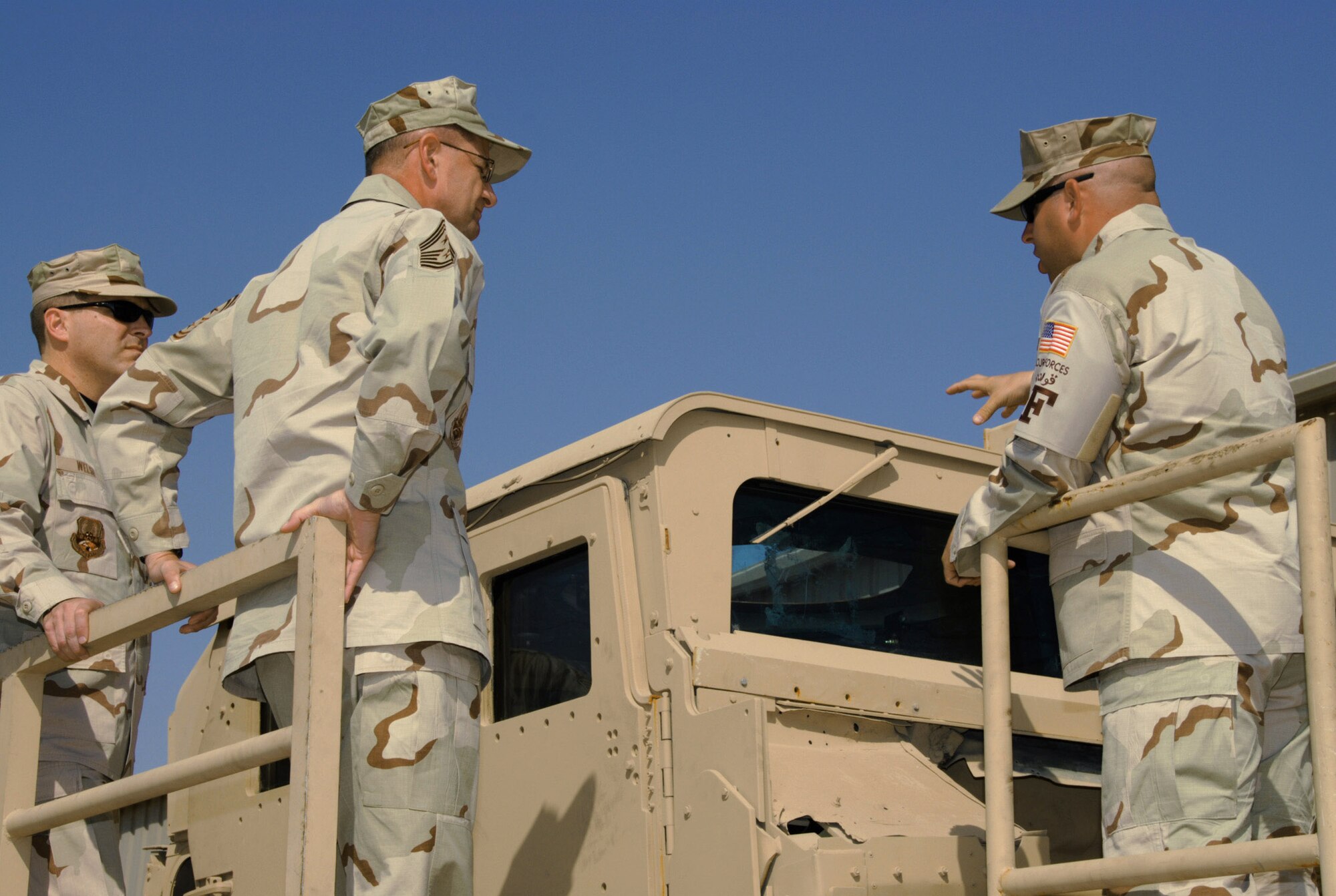 Tech. Sgt. Thomas Williamson (right) explains the rollover Humvee simulator to several members of the 379th Air Expeditionary Wing.  The simulator, located at an Army camp in Southwest Asia, is used for egress assistance training to help Airmen learn how to escape from an inverted Humvee and increase their chance of survival after a catastrophic event. (U.S. Air Force photo/Staff Sgt. Doug Olsen)