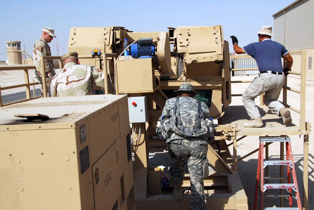 Airmen in the 379th Expeditionary Security Forces Squadron are getting specialized training at an Army camp in Southwest Asia to learn how to escape an inverted Humvee and increase their chance of survival after a catastrophic event.  Using a rollover Humvee simulator, Tech Sgt. Noah Coon (from left), Tech Sgt. Thomas Williamson, Staff Sgt. Jose Chun and Staff Sgt. Kyle Torres stand by to assist trainees inside the simulator. (U.S. Air Force photo/Staff Sgt. Doug Olsen)