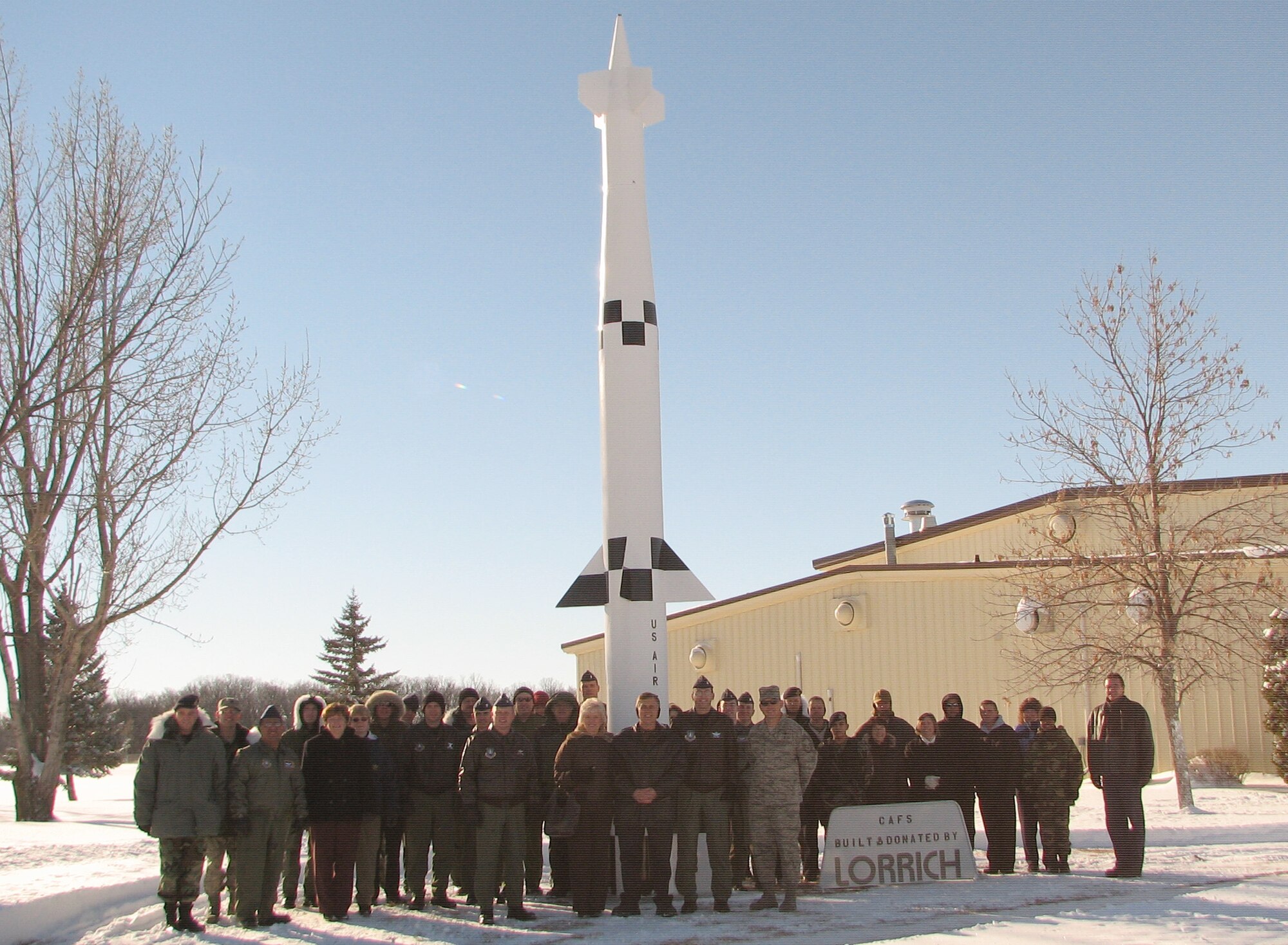 Members of the 10th Space Warning Squadron pose with a newly-dedicated display Spartan missile at Cavalier AFS, N.D. The missile, one of America’s earliest forms of missile defense, was donated to the air force station by local company Lorrich Industries. (U.S. Air Force photo/Capt. Michael Stayrook)