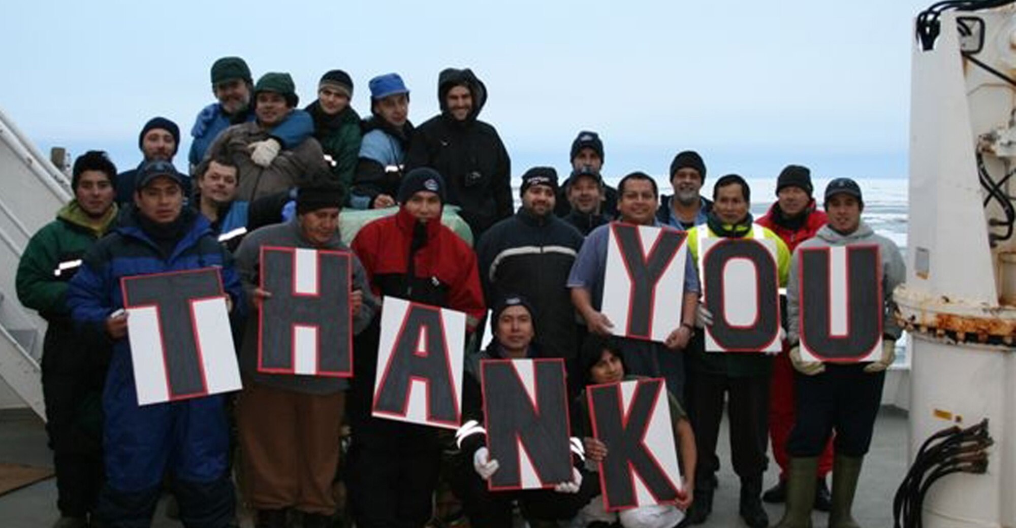 A grateful crew of the Argos Georgia show its appreciation after a McChord C-17 flown by Reserve and active-duty Airmen airdropped a new engine and supplies to the stranded fishing trawler in the Antarctic. (Courtesy photo/Argos Georgia, Ltd.)
