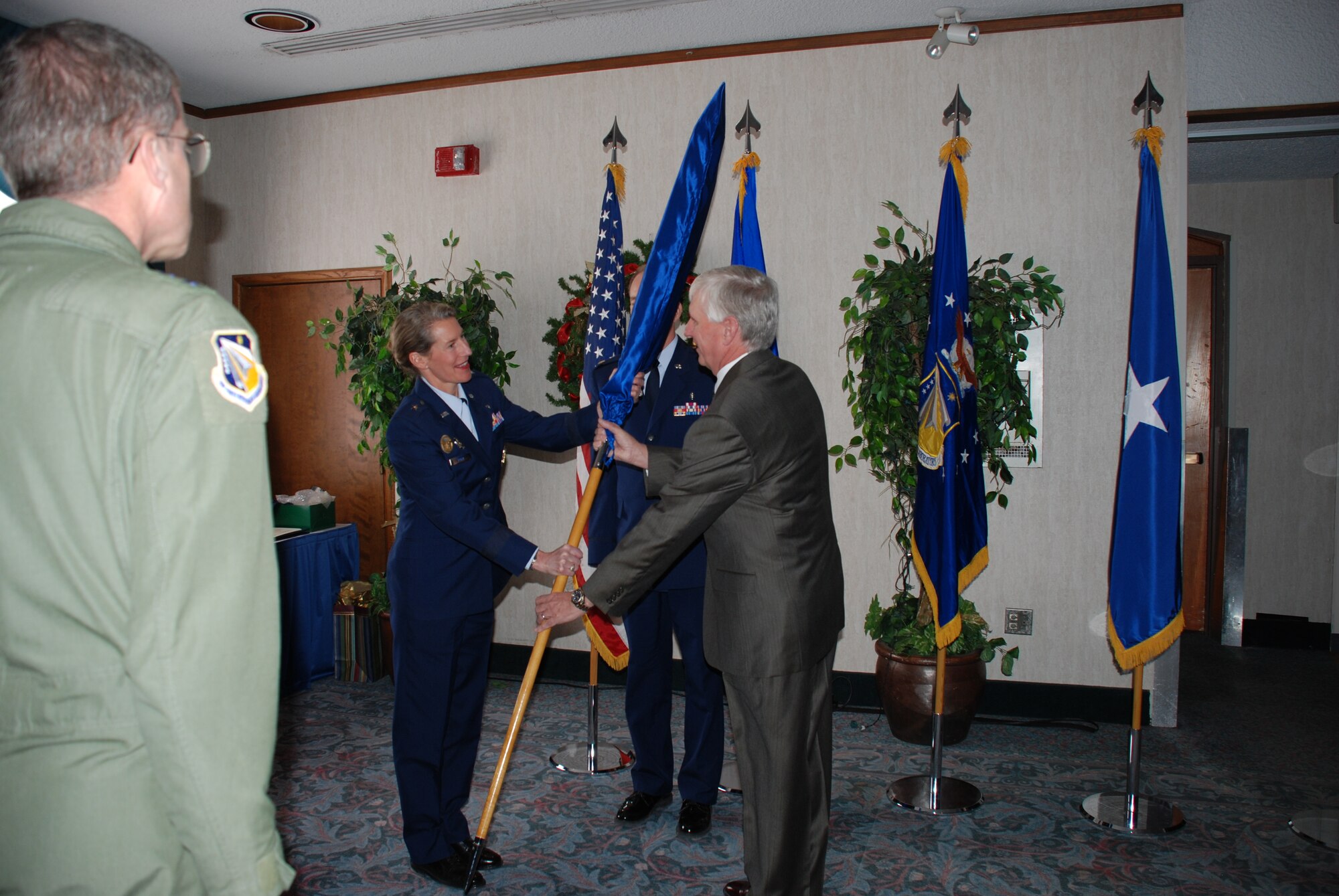 Dr. Hendrick W. "Henk" Ruck (right) accepts the furled and sheathed Senior Executive Service flag from Brig. Gen. Dana H. Born, Dean of the Faculty, U.S. Air Force Academy. Gen. Born was the featured speaker January 4 as Dr. Ruck stepped down as director of the Air Force Research Laboratory's Human Effectiveness Directorate. Looking on at left is AFRL Commander Maj. Gen. Curtis M. Bedke. (Photo by Chris Gulliford AFRL/RH)