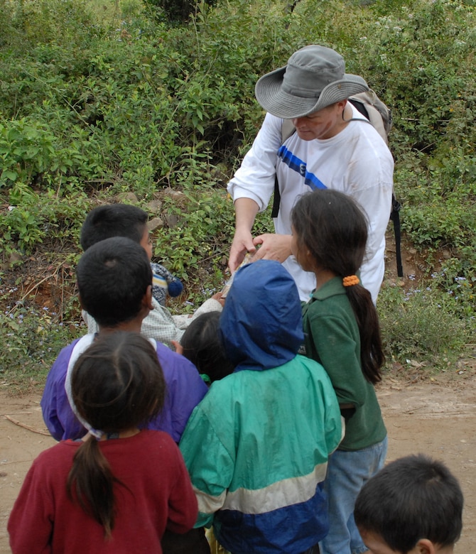 EL VOLCAN, Honduras - Air Force Lt. Col. Larry Ott, Joint Task Force-Bravo deputy commander, shares some of his snacks with local children on a hike to El Volcan planned by the JTF-Bravo chapel Jan. 5.  The seven-mile hike was the last of a series of five in which JTF-Bravo servicemembers delivered food to local villagers.  Participants in the hike to El Volcan carried toys for local children with them because the hike happened one day before Three Kings Day, a holiday which Hondurans traditionally celebrate by giving gifts to children. (Air Force photo by 1st Lt. Erika Yepsen/Joint Task Force-Bravo Public Affairs)