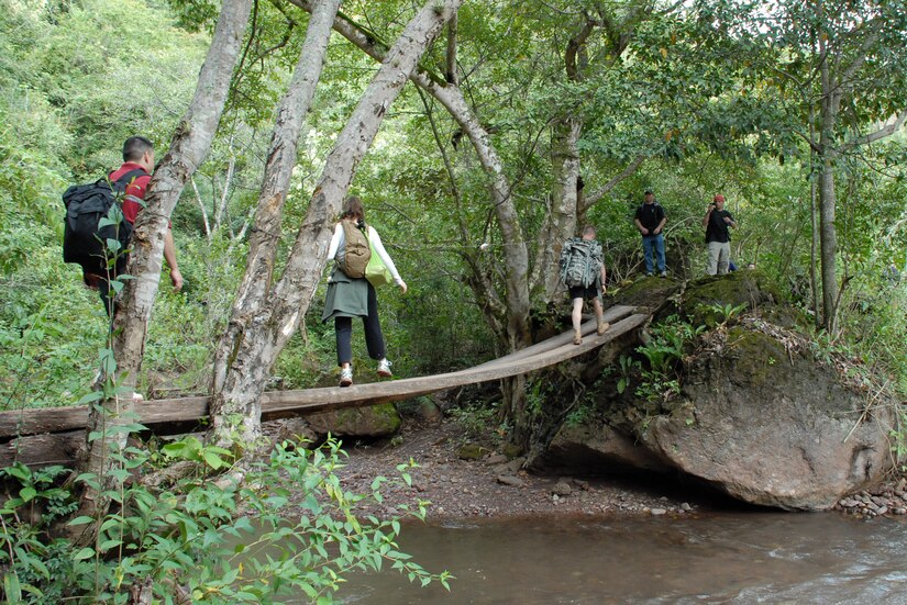 EL VOLCAN, Honduras - Servicemembers from Joint Task Force-Bravo cross a stream on a hike to El Volcan planned by the JTF-Bravo chapel Jan. 5.  The seven-mile hike was the last in a series of five in which JTF-Bravo servicemembers delivered food to local villagers.  Collectively throughout the series, more than 350 servicemembers traveled 39 miles to deliver more than 1.6 tons of food to approximately 1,800 people in five villages.  (Air Force photo by 1st Lt. Erika Yepsen/Joint Task Force-Bravo Public Affairs)