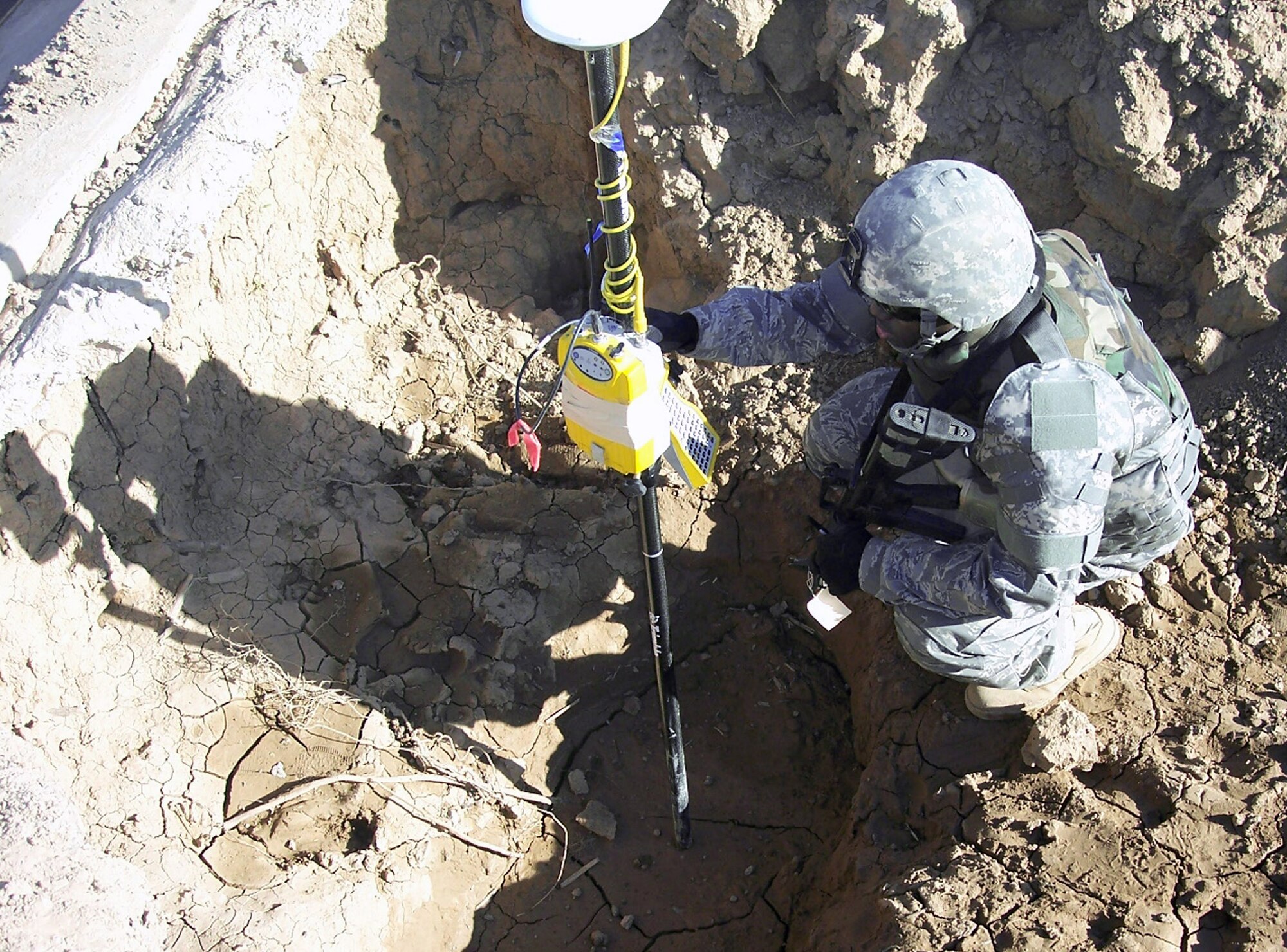 Senior Airman Renardo Sanders climbs down into a ditch near a levee Jan. 7 outside of Balad Air Base, Iraq, to collect elevation data. Airman Sanders is a 732nd Expeditionary Civil Engineering Squadron engineering assistant deployed from Beale Air Force Base, Calif. (U.S. Air Force photo/Capt. Christopher Mercer) 