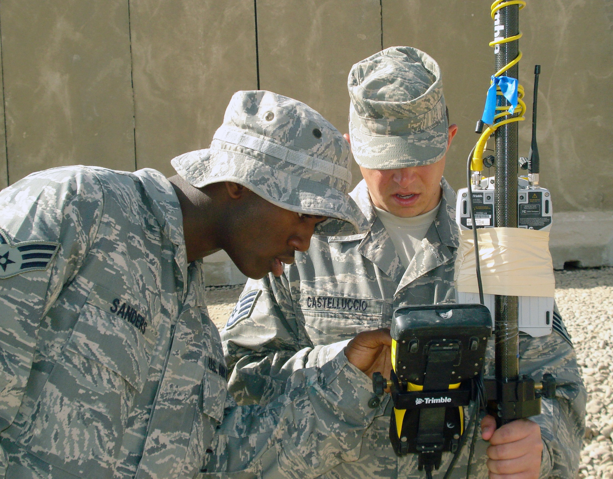 Senior Airman Renardo Sanders (left) and Staff Sgt. Frank Castelluccio set up a handheld surveying machine Jan. 7 in preparation for a topographical survey outside Balad Air Base, Iraq. The survey was used to map out the joint drainage layout. Both Airmen are 732nd Expeditionary Civil Engineering Squadron engineering assistants. Sergeant Castelluccio is deployed from Kadena Air Base, Japan, and Airman Sanders is deployed from Beale Air Force Base, Calif. (U.S. Air Force photo/Staff Sgt. Ishanti Holmes) 