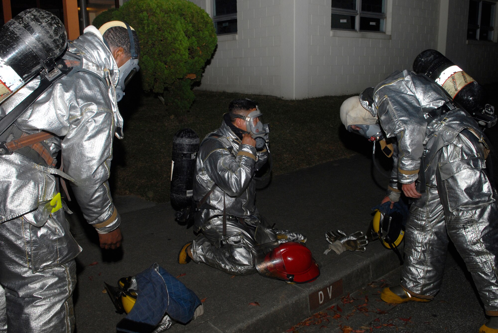 Firefighters assigned to the 18th Civil Engineer Group vacate a building after responding to a fire and bug out scenario at the 961st Airborne Air Control Squadron during Local Operational Readiness Exercise Beverly High 08-3 at Kadena Air Base, Japan, Jan. 7, 2007. The 18th Wing coducted the exercise from Jan. 7 to 11 to test the wing's ability to respond in contingency situations.                                            (U.S. Air Force photo/Staff Sgt. Chrissy FitzGerald)