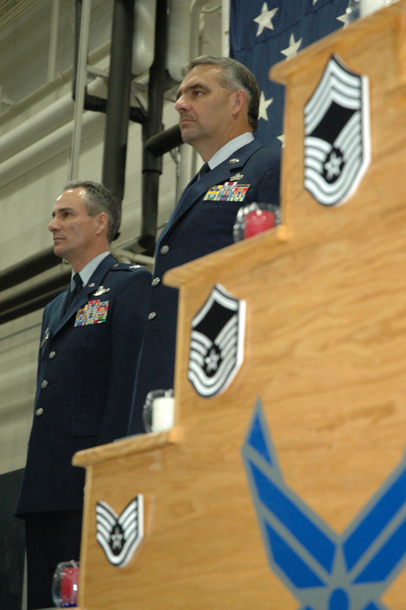 YOUNGSTOWN AIR RESERVE STATION, Ohio — Air Force Reserve Chief Master Sgt. Robert V. Glus Sr., Command Chief Master Sergeant of the 910th Airlift Wing (right) stands at attention during the playing of the National Anthem alongside Col. Karl McGregor, commander of the 910th Airlift Wing, during Chief Glus' retirement ceremony January 6, 2008.  Chief Glus retired after a total of 33 years of military service, 26 of which were spent as a member of the 910th Airlift Wing. U.S. Air Force photo/Tech. Sgt. Bob Barko Jr.