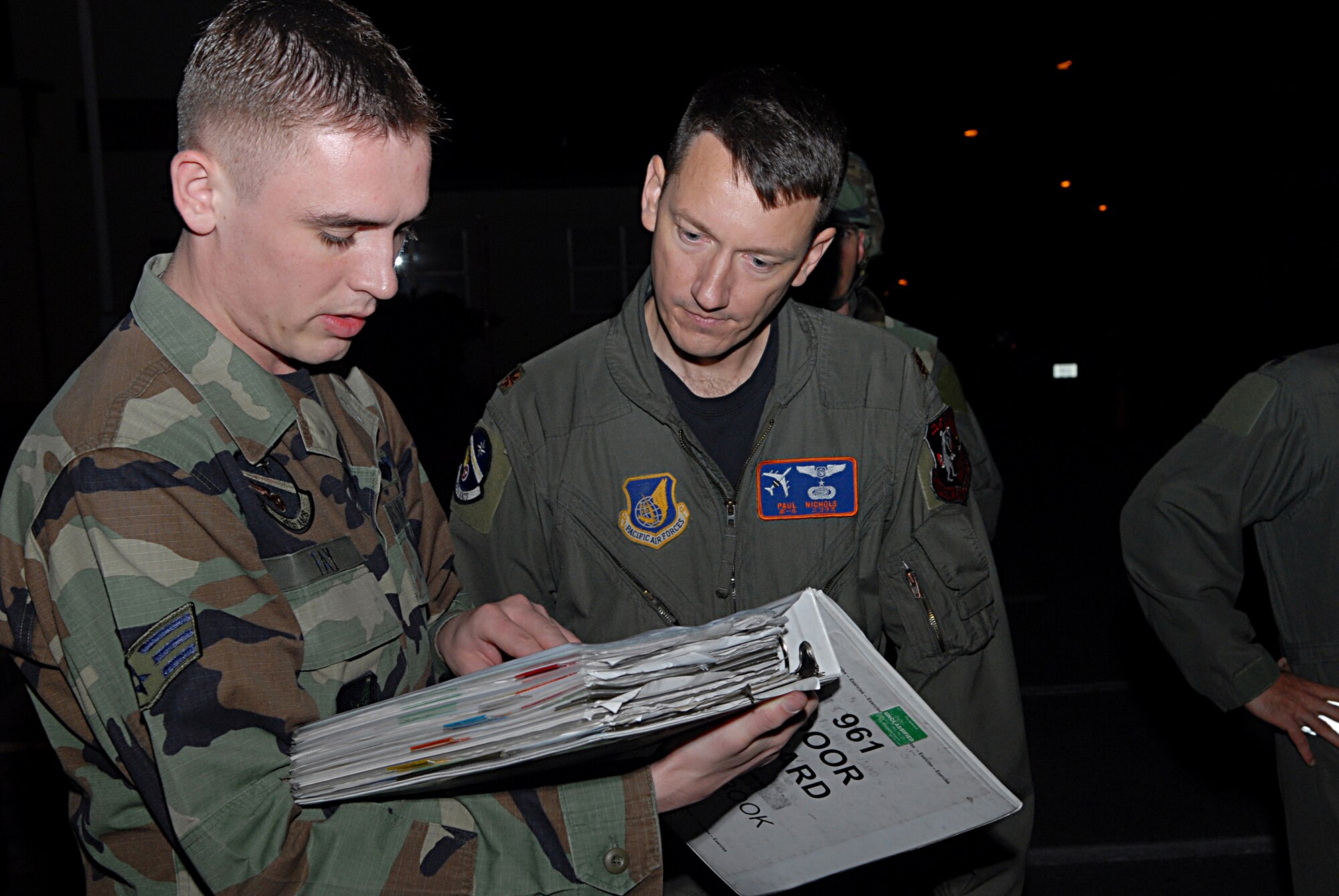 Senior Airman Joseph Fay and Maj. Paul Nichols conduct a role call for accountability of their Airmen during a fire and bug out scenario at the 961st Airborne Air Control Squadron during Local Operational Readiness Exercise Beverly High 08-3 at Kadena Air Base, Japan, Jan. 7, 2007. The 18th Wing conducted a LORE exercise from Jan. 7 to 11 to test the wing's ability to respond in contingency situations.            
(U.S. Air Force photo/Staff Sgt. Chrissy FitzGerald)