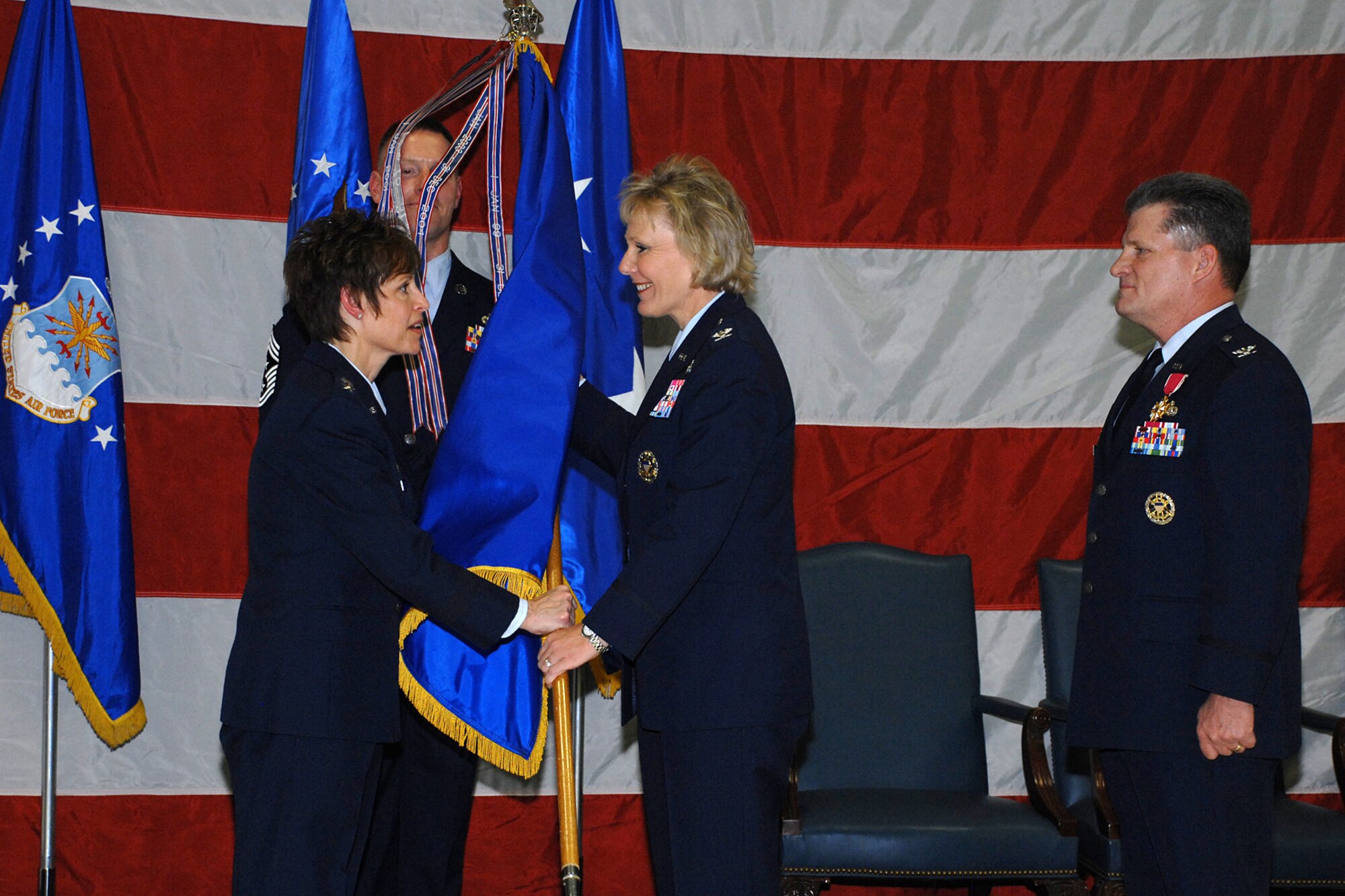 Col. Linda R. Medler, 75th Air Base Wing commander, accepts the wing's guidon from Maj. Gen. Kathleen Close, Ogden Air Logistics Center commander and the presiding official, during a change-of-command ceremony Jan. 4. U.S. Air Force photo by Alex R. Lloyd.