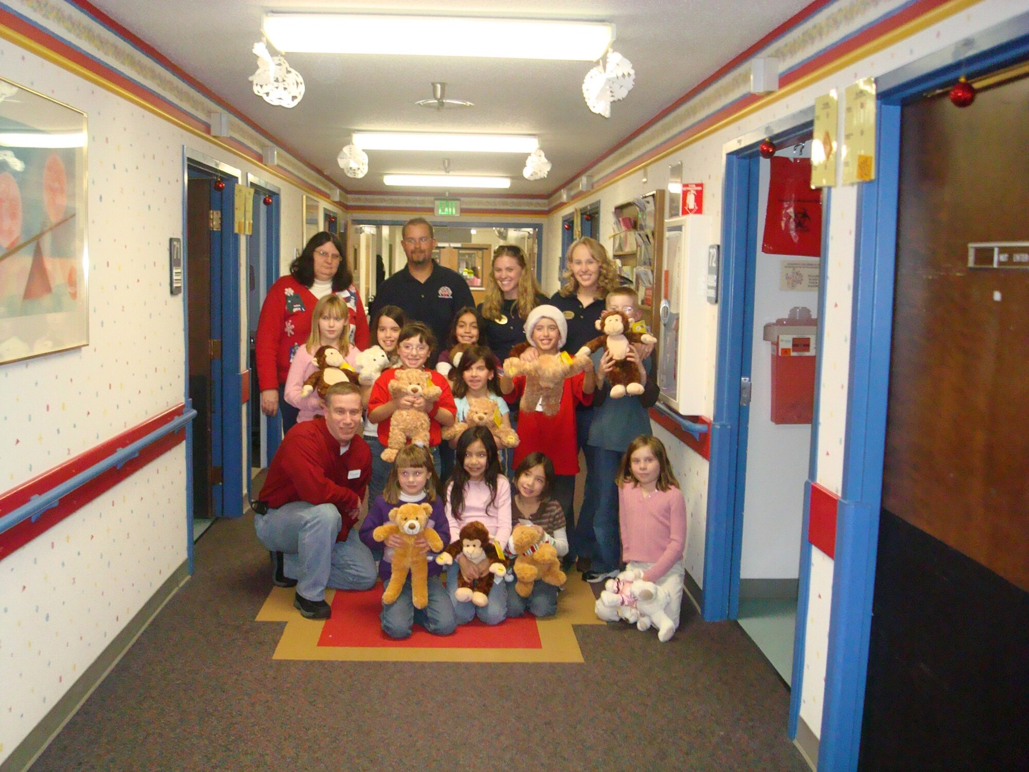 Staff Sgt. Thomas Moore (bottom row, left) poses for a shot with children of the Air Force Academy's Falcon Trail Youth Center during a delivery of more than 160 teddy bears to the Penrose Community Hospital Pediatrics Department. Sergeant Moore, assigned to the Space Missile Systems Center at Peterson AFB, Colo., began the program in 2002 and has been spearheading the community project every year since. (Courtesy photo)