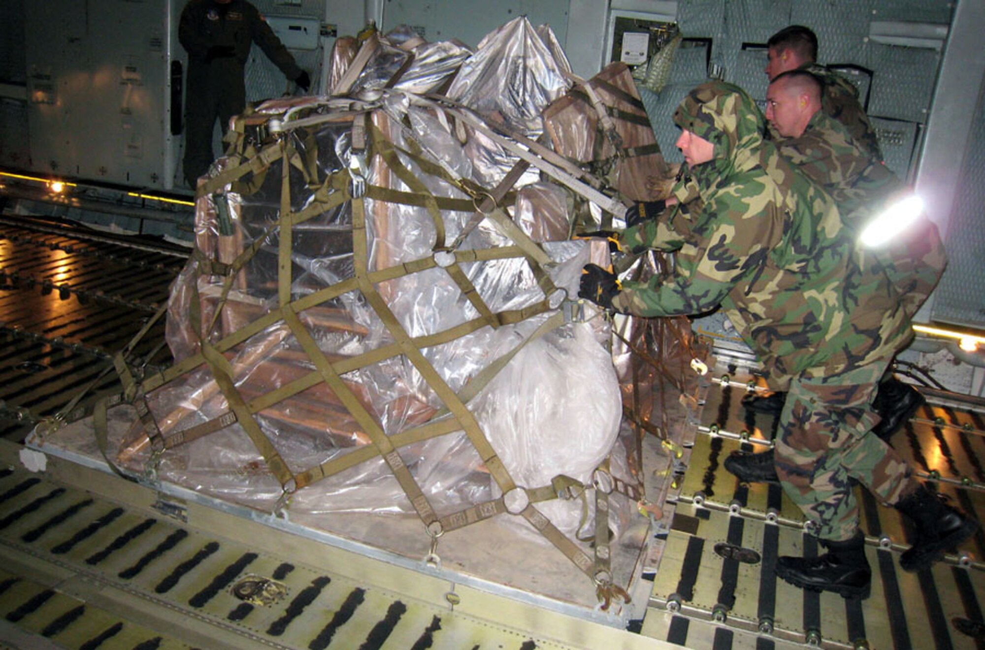 Tech. Sgt. Michael Lombard, Senior Airman Zachary Walker and Senior Airman Paul Phillips push a loaded pallet into the C-5’s cargo area. All are Air Force reservists with the 507th Air Refueling Wing's 72nd Aerial Port Squadron.