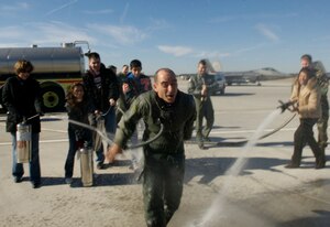 LANGLEY AIR FORCE BASE, Va --  After flying his final sortie at here, Col. Jeffrey Harrigian, 1st Fighter Wing vice commander, is greeted by his wife and children with fire extinguishers to celebrate his final mission at the installation. Colonel Harrigian is leaving Langley to assume command of the 49th Fighter Wing at Hollman Air Force Base, N.M. (U.S. Air Force photo/Staff Sgt. Samuel Rogers)