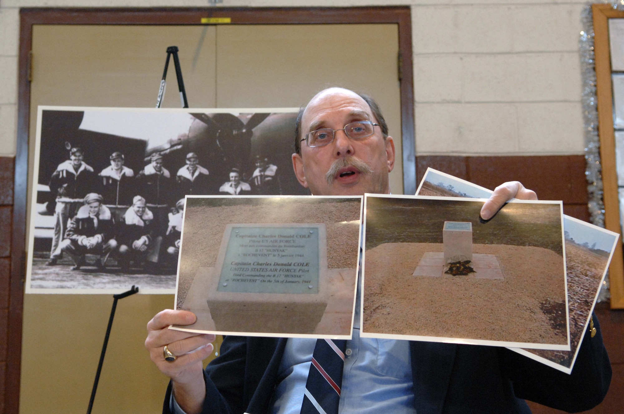 SHAW AIR FORCE BASE, S.C. -- Donald Cole Walters, son of fallen World War II B-17 pilot Capt. Donald Cole, shows photos of the memorial to his father near the French village Nieul-les-Saintes before being presented his father's watch at the Asheville, N.C. National Guard Armory Dec. 28, 2007. Capt. Cole stayed at the controls of his wounded B-17 that caught ablaze after being hit by German antiaircraft fire so that his nine fellow crewmembers could parachute to safety. He then steered the plane away from the French village of Nieul-les-Saintes, crashing it into a nearby field Jan. 5, 1944. In 2001, the residents of Nieul-les-Saintes had invited Donald Walters to France to attend a memorial dedication ceremony to his father for his sacrifice.  (U.S. Air Force photo/A1C Kathrine McDowell)