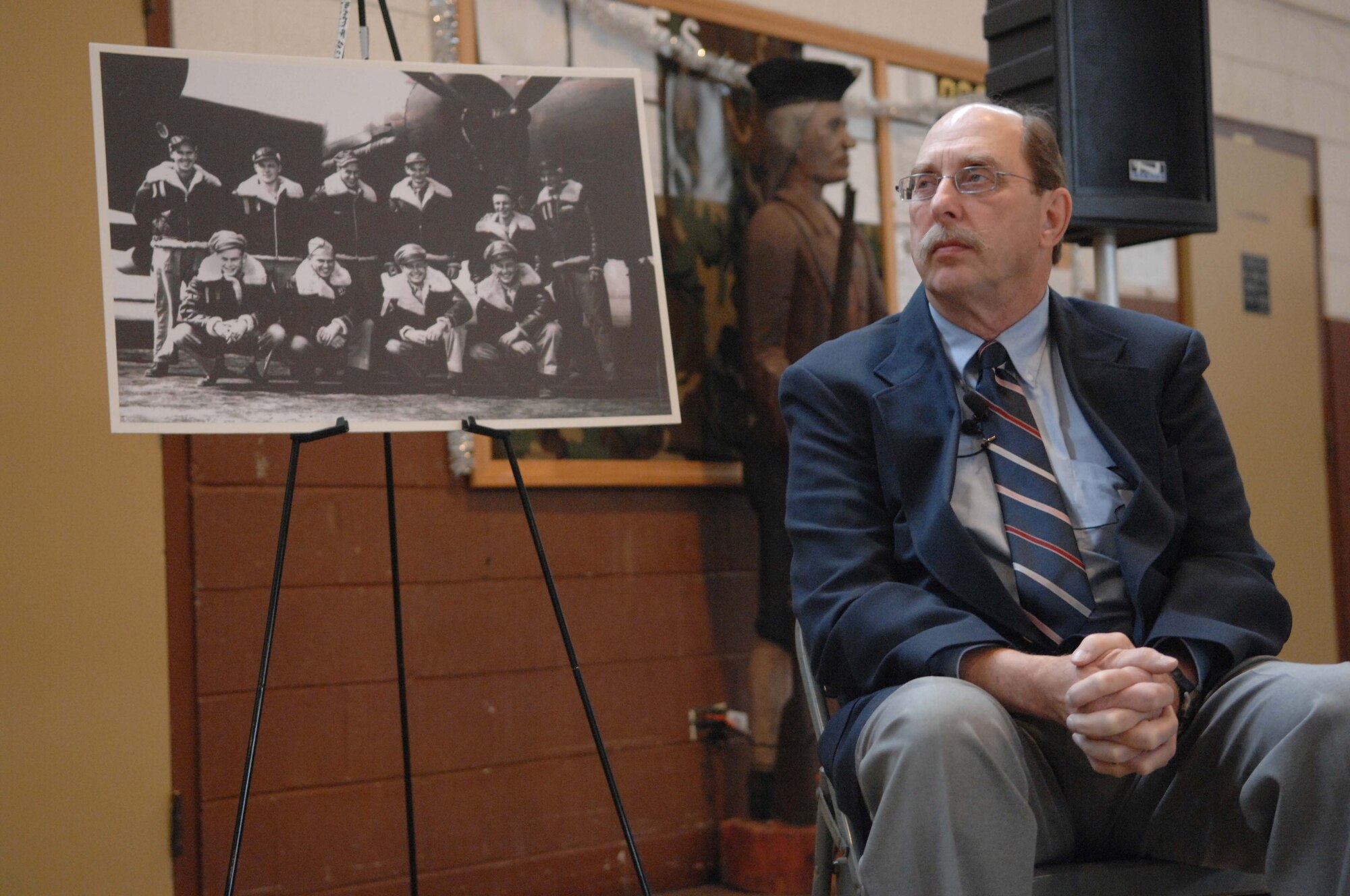SHAW AIR FORCE BASE, S.C. -- Donald Cole Walters, son of fallen World War II B-17 pilot Capt. Donald Cole, sits by a photo of his father and crew before being presented his father's watch at the Asheville, N.C. National Guard Armory Dec. 28, 2007. Capt. Cole stayed at the controls of his wounded B-17 that caught ablaze after being hit by German antiaircraft fire so that his nine fellow crewmembers could parachute to safety. He then steered the plane away from the French village of Nieul-les-Saintes, crashing it into a nearby field Jan. 5, 1944. (U.S. Air Force photo/A1C Kathrine McDowell)