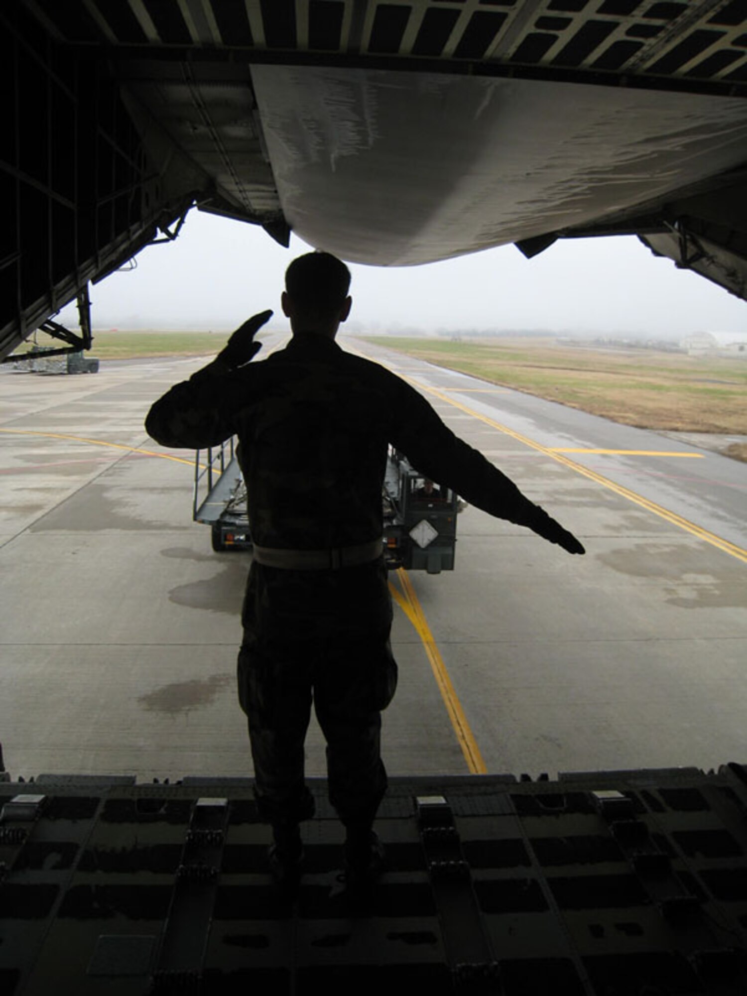 An Air Force reservist from the 507th Air Refueling Wing's 72nd Aerial Port Squadron provides direction for a loader operator as a loading vehicle is driven to the back of the C-5 ramp to unload cargo during a recent training session.