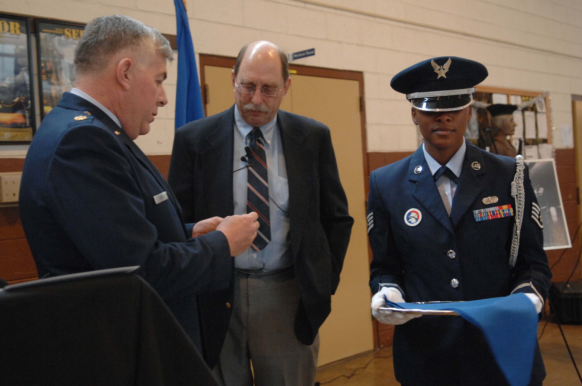 SHAW AIR FORCE BASE, S.C. -- Maj. William Cassida, Defense Attache from the U.S. Embassy in France, takes the watch of fallen bomber pilot Capt. Donald Cole from Staff Sgt. Telissa Diggs, Shaw Air Force Base Honor Guard, to present it to Capt. Cole's son, Donald Cole Walters, at the Asheville, N.C. National Guard Armory Dec. 28, 2007. Capt. Cole stayed at the controls of his wounded B-17 that caught ablaze after being hit by German antiaircraft fire so that his nine fellow crewmembers could parachute to safety. He then steered the plane away from the French village of Nieul-les-Saintes, crashing it into a nearby field Jan. 5, 1944. (U.S. Air Force photo/A1C Kathrine McDowell)