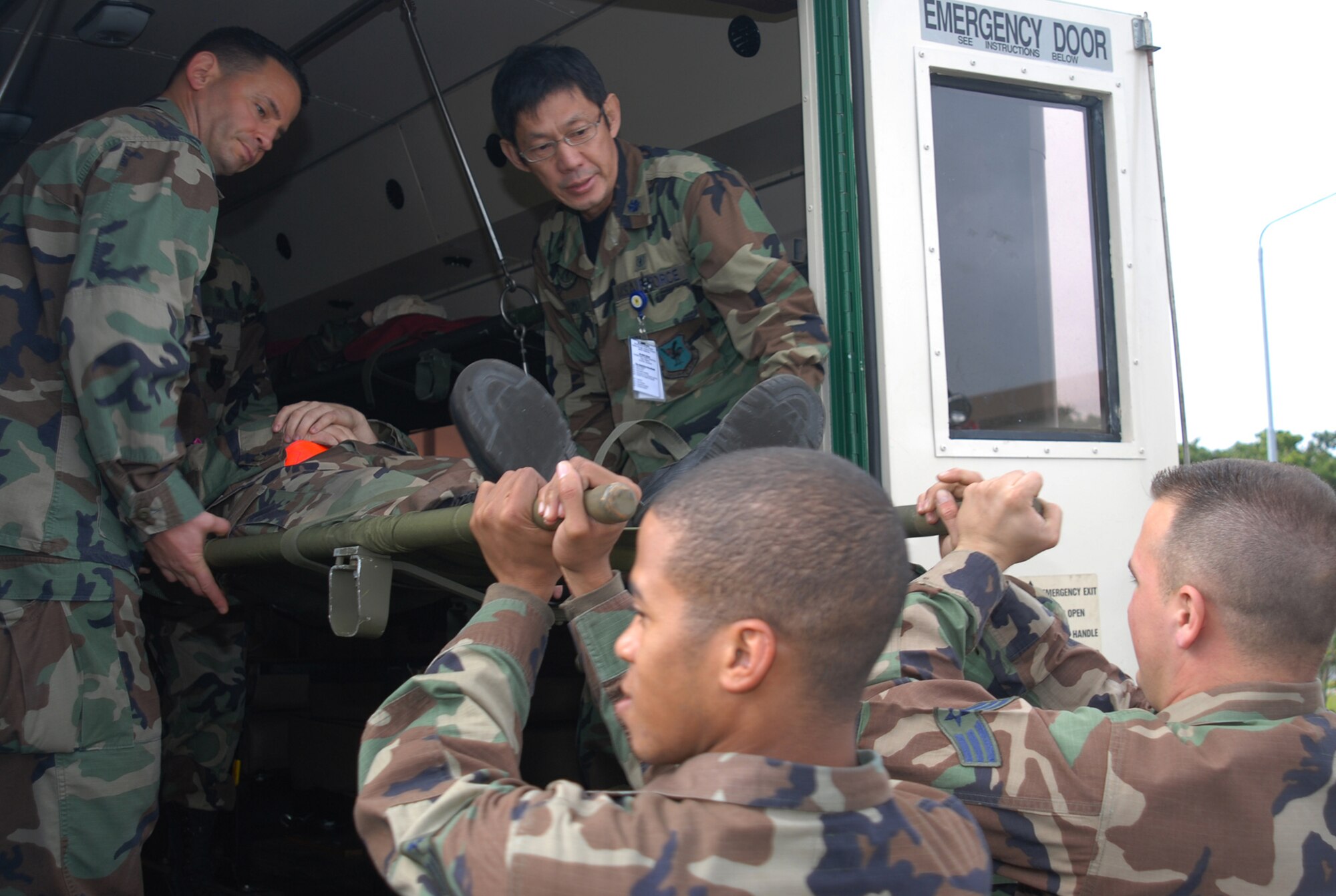 Lt. Col. Todd Lincoln and Lt. Col. Wataru Odomo, both from the 18th Dental Squadron, receive a patient for transport following a simulated explosion of the Marshall Dining Facility during Local Operational Readiness Exercise Beverly High 08-3 at Kadena Air Base, Japan, Jan. 7, 2007. The 18th Wing exercise from Jan. 7 to 11 tests the wing's ability to respond to wartime situations.   (U.S. Air Force photo/Tech. Sgt. Dave DeRemer)