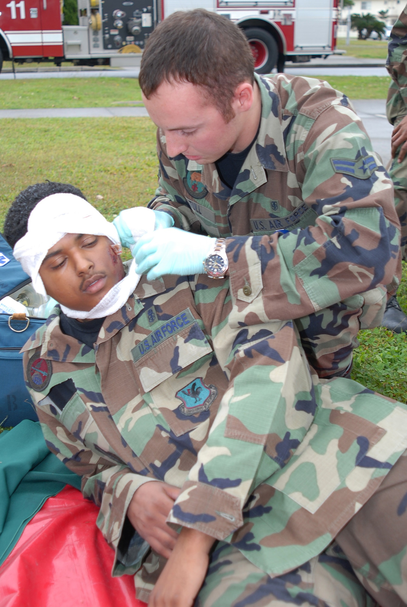 Airman First Class Michael Stull, 18th Aerospace Medical Squadron, bandages the head of a wounded victim following a simulated explosion of the Marshall Dining Facility during Local Operational Readiness Exercise Beverly High 08-3 at Kadena Air Base, Japan, Jan. 7, 2007. The 18th Wing exercise from Jan. 7 to 11 tests the wing's ability to respond in contingency situations.   (U.S. Air Force photo/Tech. Sgt. Dave DeRemer)