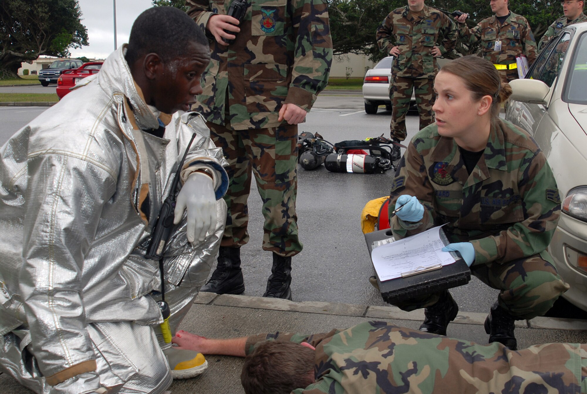 Senior Airman Ashley Sard, 18th Medical Operations Squadron, gets victim information from a firefighter following a simulated explosion at the Marshall Dining Facility during Local Operational Readiness Exercise Beverly High 08-3 at Kadena Air Base, Japan, Jan. 7, 2007. The 18th Wing exercise from Jan. 7 to 11 tests the wing's ability to respond in contingency situations.   (U.S. Air Force photo/Tech. Sgt. Dave DeRemer)