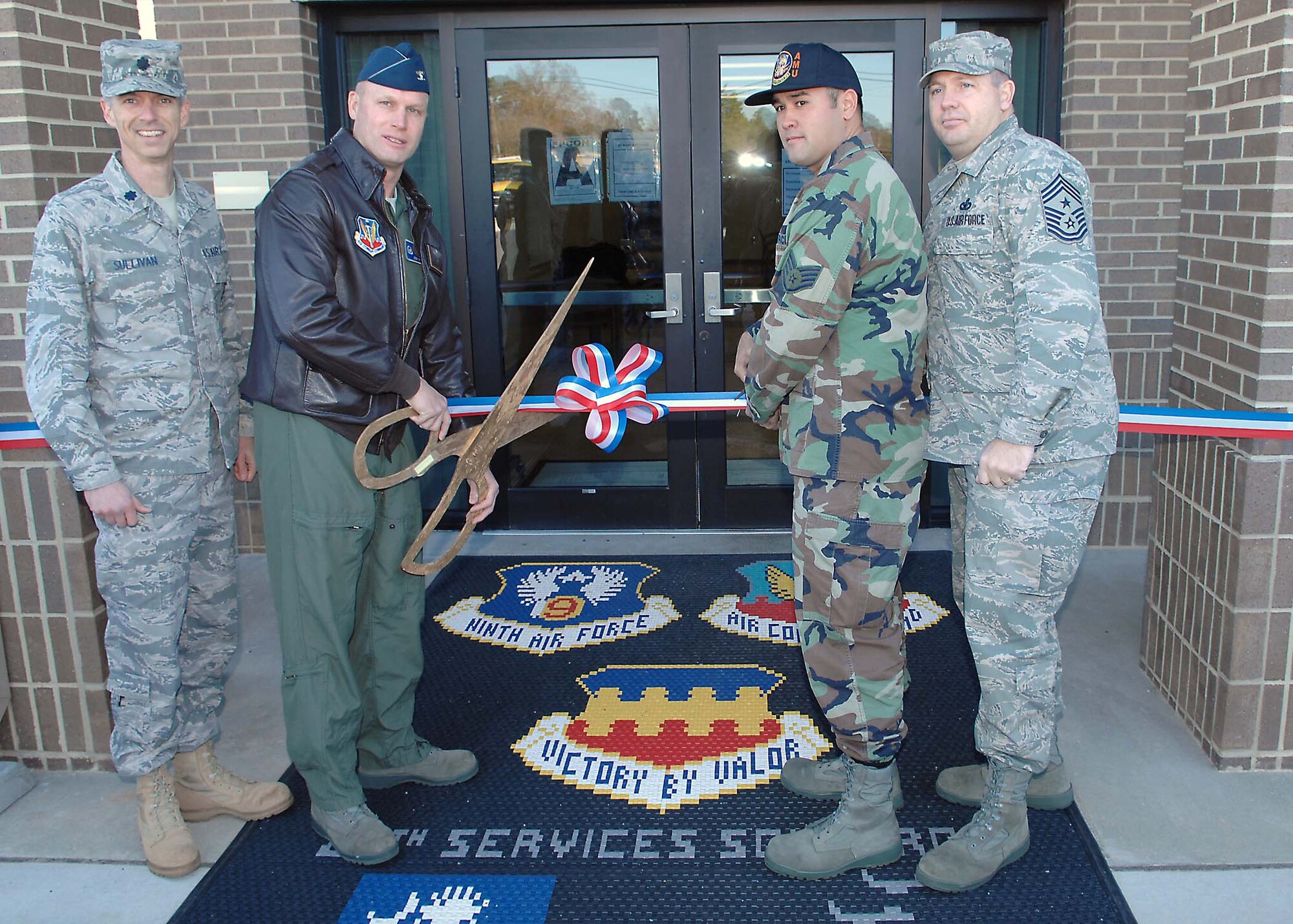 SHAW AIR FORCE BASE, S.C. -- Col. James Post, 20th Fighter Wing commander, cuts the ribbon to signify the official opening of Shaw's Afterburner Grill Jan. 3. Joining the colonel is Lt. Col. Jimmie Sullivan, 20th Force Support Squadron commander, Staff Sgt. Billy Joe Wheeling, 79th Aircraft Maintenance Unit, and Chief Master Sgt. Scott Dearduff, 20th FW command chief. The new grill was built to provide flightline members and transit personnel more convenience to get a meal. Sergeant Wheeling came up with the name Afterburner Grill and received a gift certificate for a two-day stay in a hotel in Myrtle Beach, S.C. (U.S. Air Force photo/Airman 1st Class William Coleman)