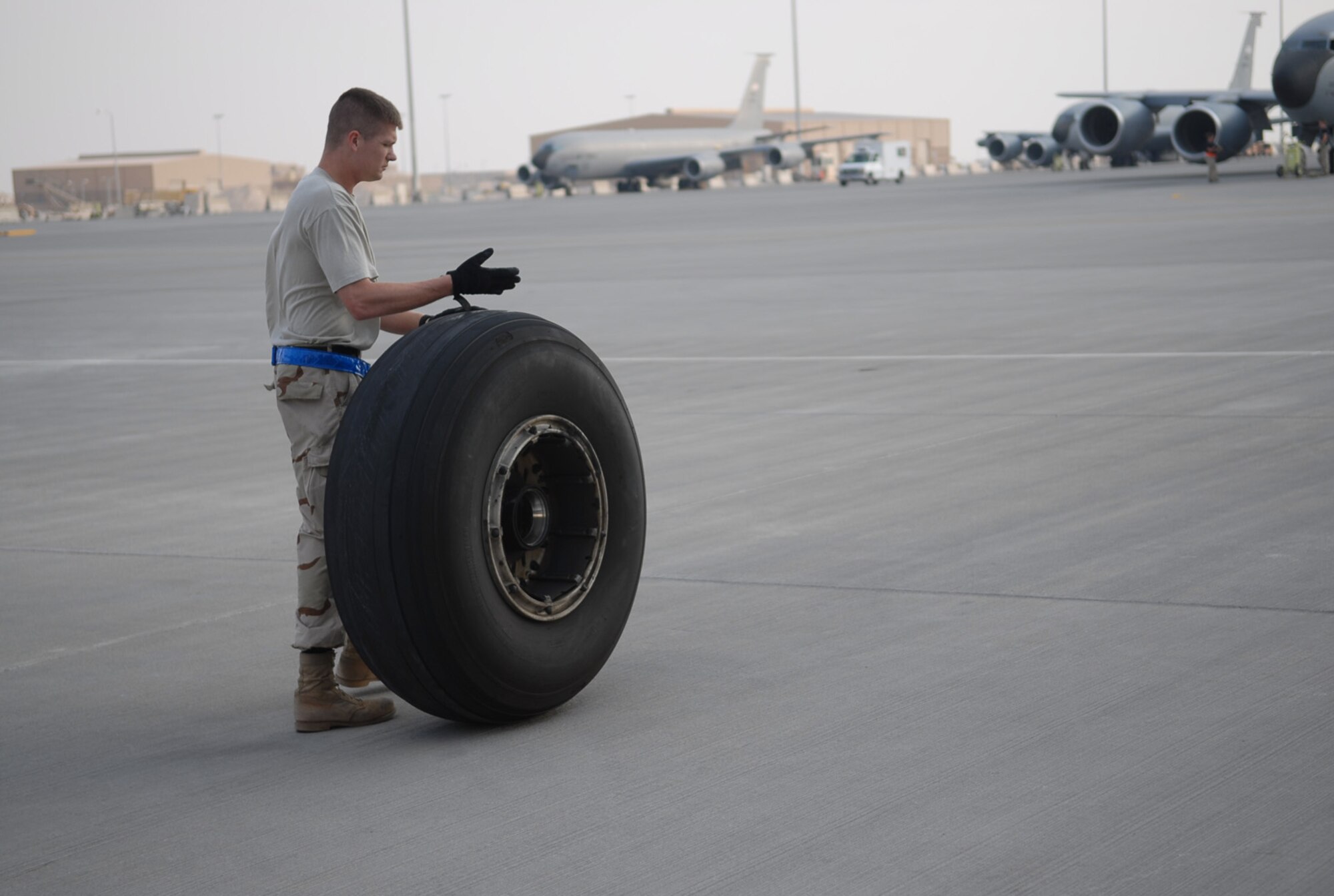 SOUTHWEST ASIA - Staff Sgt. Frank Veres, 379th Expeditionary Aircraft Maintenance Squadron crew chief, deployed from Fairchild Air Force Base, Wash., rolls a worn tire away from a KC-135 Stratotanker at a Southwest Asia air base Jan 5. Sergeant Veres is originally from Toledo, Ohio. (U. S. Air Force photo/Staff Sgt. Douglas Olsen)