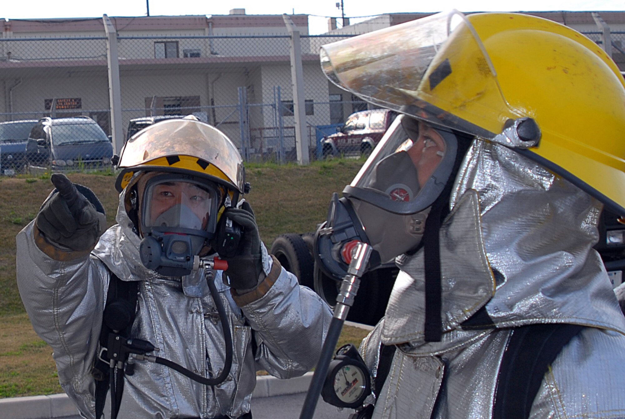Masao Itokazu and Tsuha Jitsuhito, firefighters with the 18th Civil Engineer Squadron, inspect the exterior of a building following a simulated fuel spill scenario during Local Operational Readiness Exercise Beverly High 08-3 at Kadena Air Base, Japan, Jan. 7, 2007. The exercise tested the wing's ability to respond in contingency situations. (U.S. Air Force photo/Tech Sgt. Dave DeRemer)