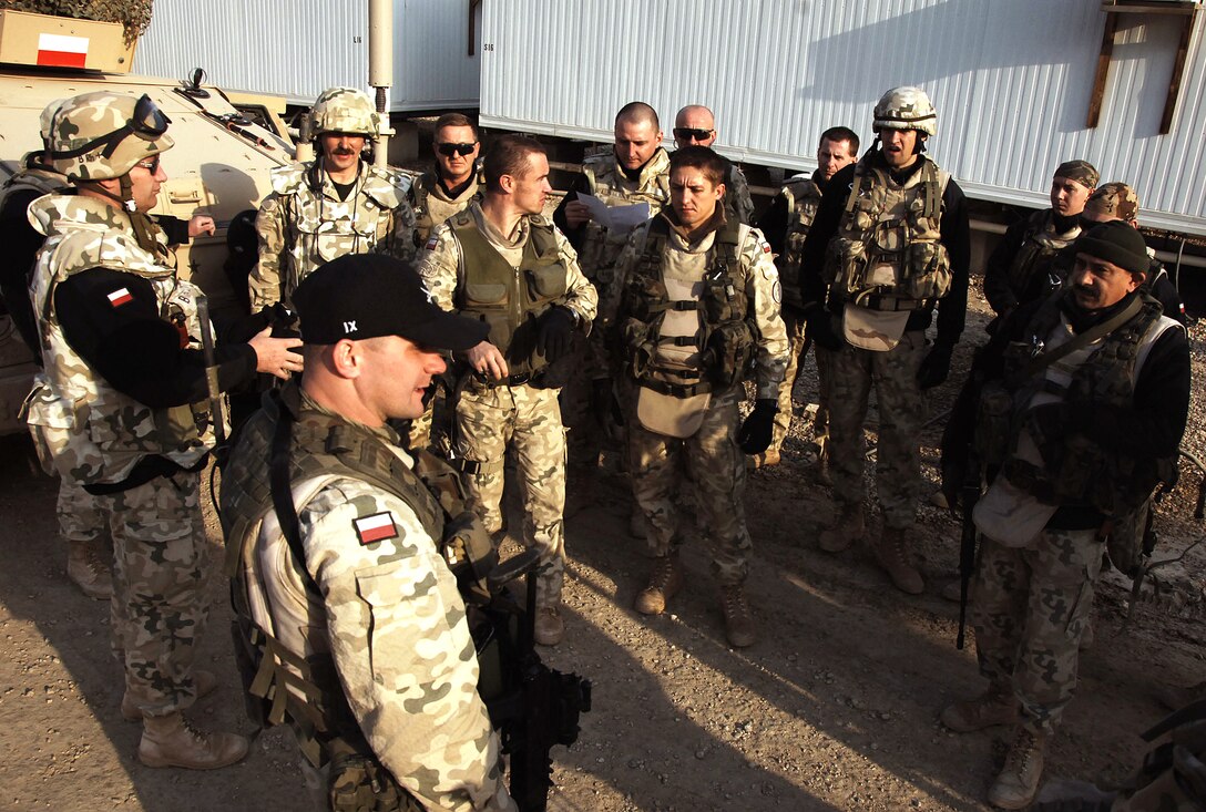 A Polish army unit conducts a convoy brief before heading out on a mission from Camp Echo, Iraq, Dec. 30, 2007.