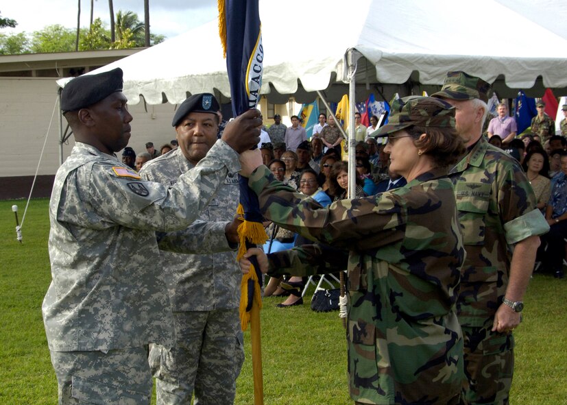 U.S Navy Rear Adm. Donna L. Crisp, incoming Commander of the Joint POW/MIA Accounting Command, hands off the JPAC flag to U.S. Army Sgt. Maj. Jackie Brown, JPAC, after receiving it from U.S. Navy Adm. Timothy J. Keating, Commander, Pacific Command, during JPAC's change-of-command ceremony at Hickam A.F.B., Hawaii, Jan. 4. Crisp is taking command from Brig. Gen. Michael C. Flowers, who is retiring. Keating is officiating over the ceremony. JPAC's mission is to achieve a full accounting of U.S. servicemembers lost during our countries previous conflicts. (U.S. Air Force photo by Staff Sgt. Derrick C. Goode)