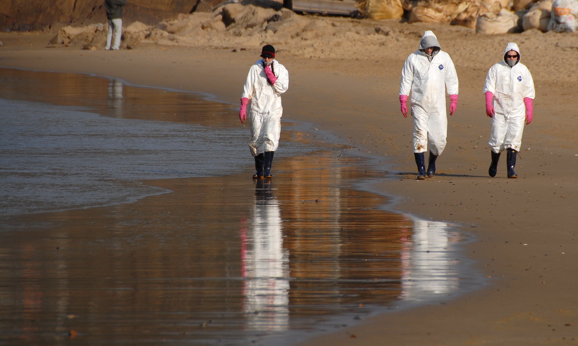 Taean, Republic of Korea -- United States Air Force Airmen from Osan Air Base walk along the beach in Taean City Thursday at the landing site of December's major crude oil spill. Hundreds of American military personnel have joined the hordes of volunteers along local coastlines who are assisting with the clean-up effort. (U.S. Air Force Photo by Senior Airman Chad Strohmeyer) 
