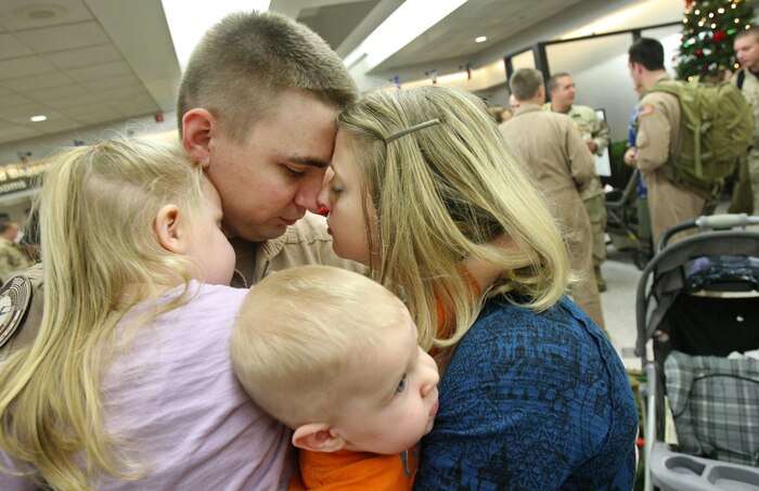 1st Lt. Kevin Thorsell, 17th Airlift Squadron, shares a quiet moment with wife, Heather, and children, Anna, 3, and Ethan, 6 months, at the passenger terminal Dec. 29 here  on  Charleston AFB. This is the first time Lieutenant Thorsell has been deployed since the birth of both children. (The Post and Courier)
