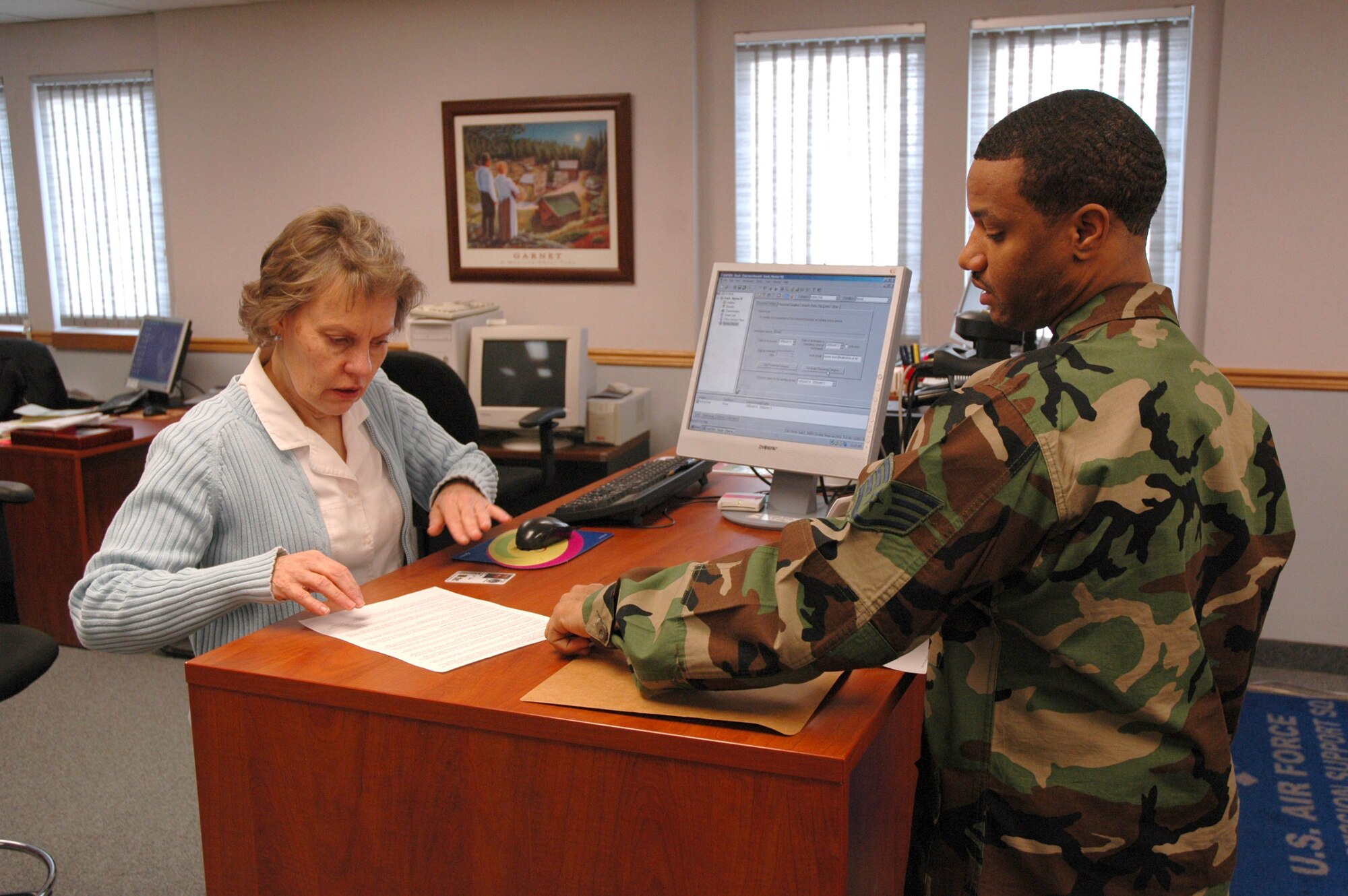 Judy Kloppel, 341st Mission Support Squadron Military Personnel Element customer service representative, assists Staff Sgt. Myster Duck, 819th RED HORSE Squadron heating ventilation and cooling technician, with paperwork Jan. 8. (U.S. Air Force photo/Airman 1st Class Dillon White)